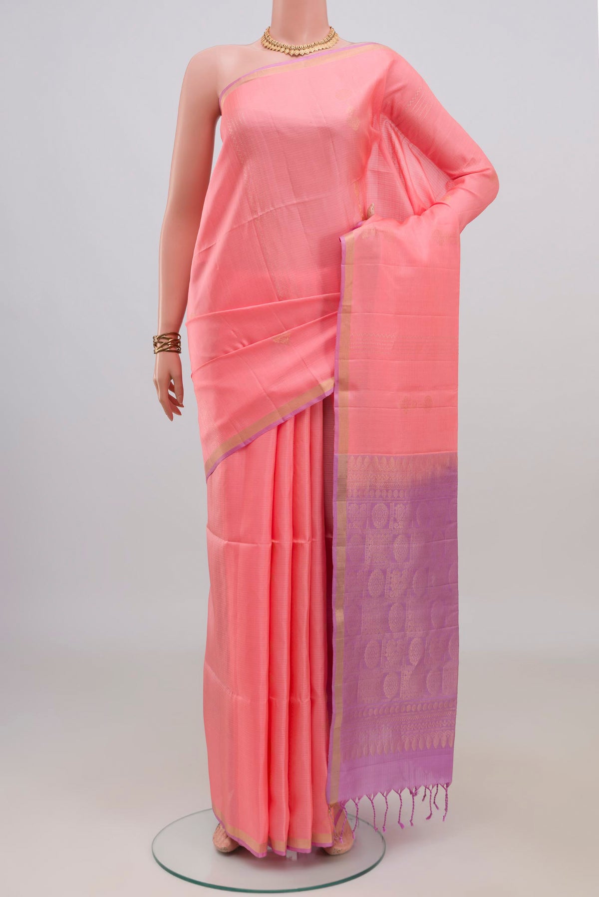 Pure Silk Peach Soft Saree with Zari Butta on the body and Thin Zari Line.  displayed on a mannequin