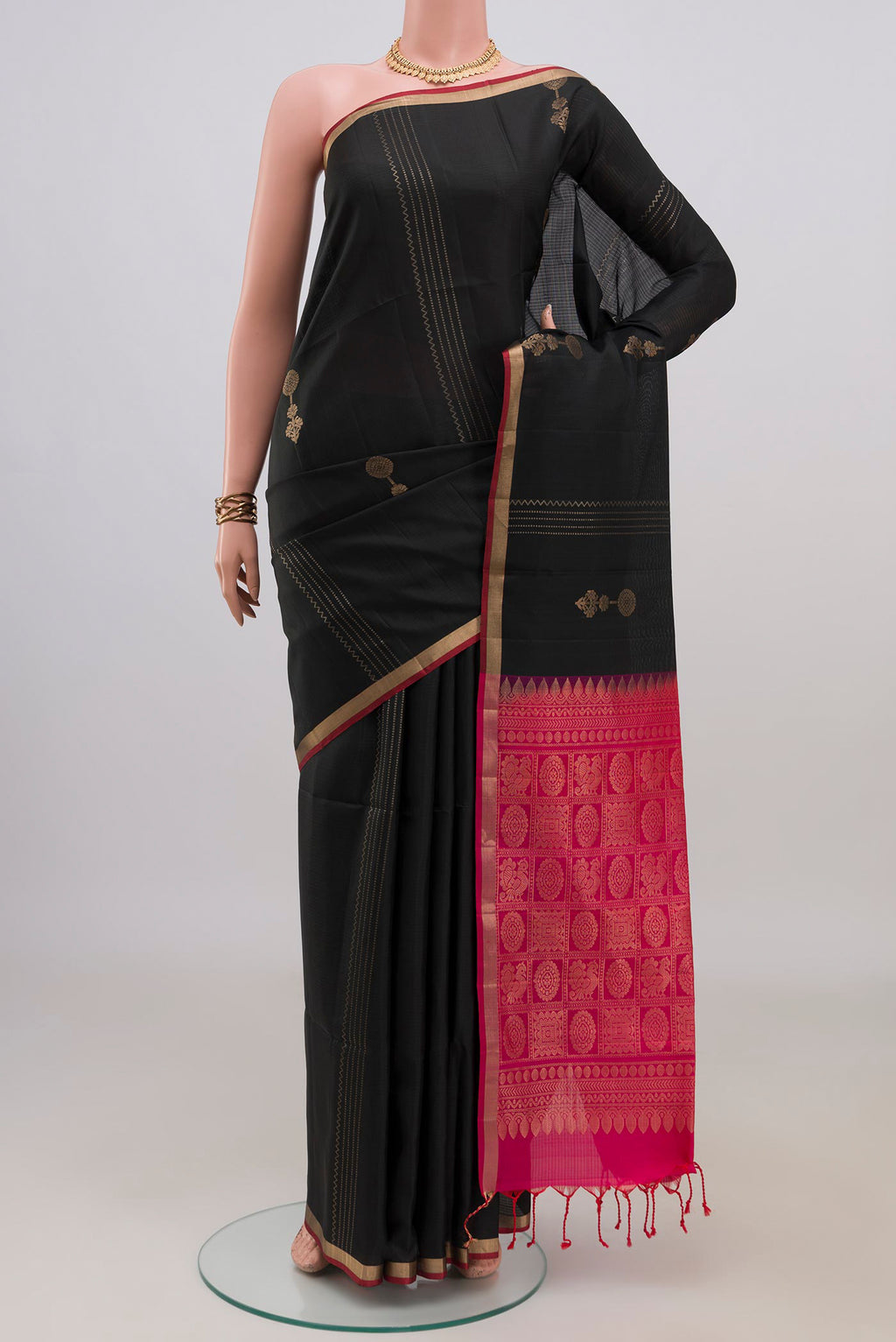 Pure Silk Black Soft Saree with Zari Butta on the body and Thin Zari Line.  displayed on a mannequin
