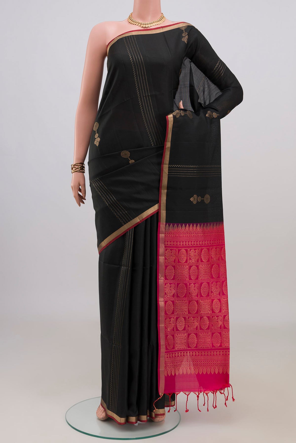Pure Silk Black Soft Saree with Zari Butta on the body and Thin Zari Line.  displayed on a mannequin