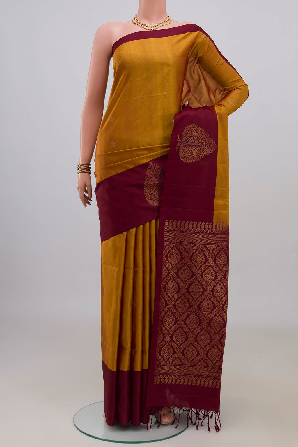 Pure Silk Mustard Soft Saree with Zari Butta on the body and Plain Border.  displayed on a mannequin
