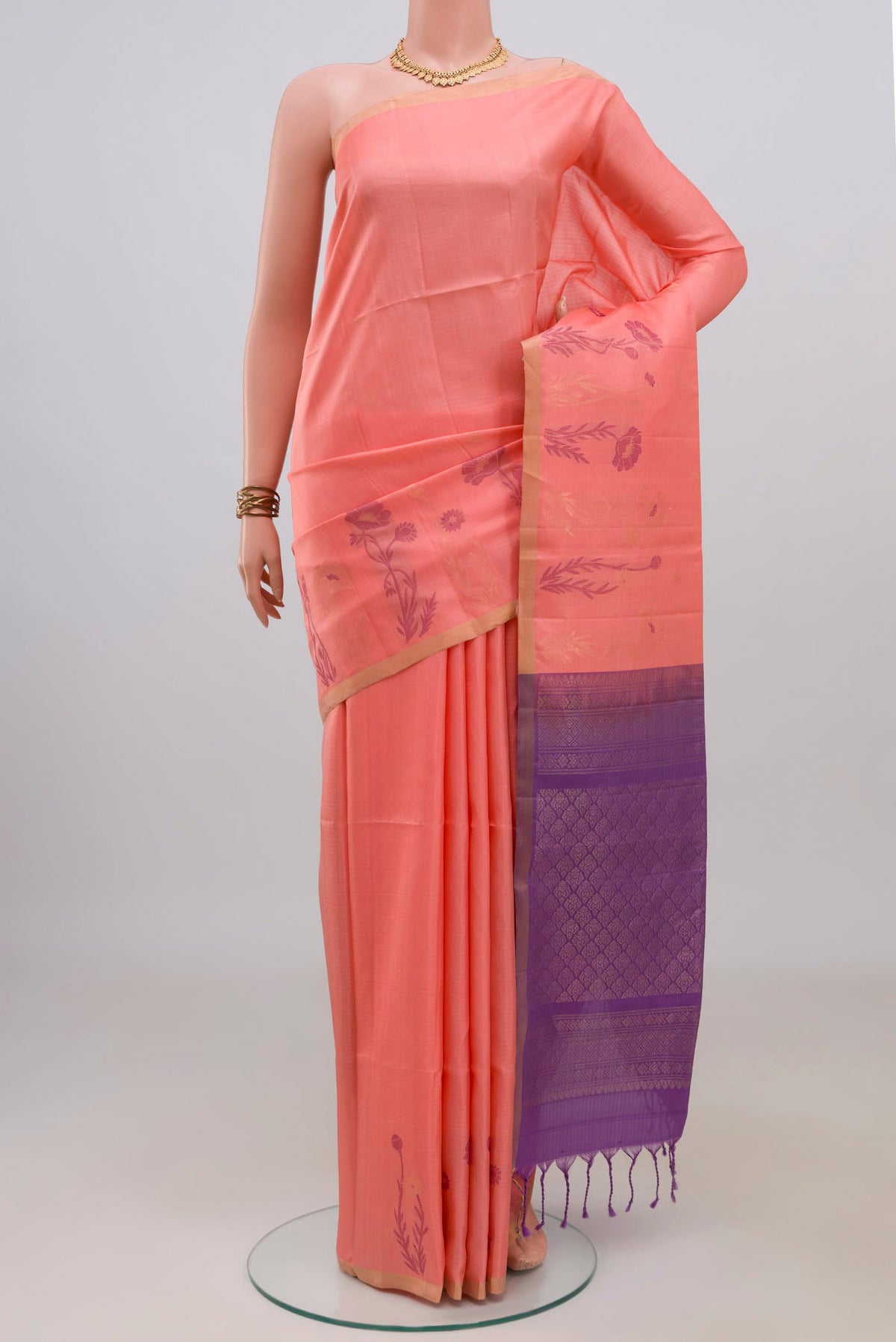 Pure Silk Peach Soft Saree with Zari Butta on the body and Thin Zari Line.  displayed on a mannequin