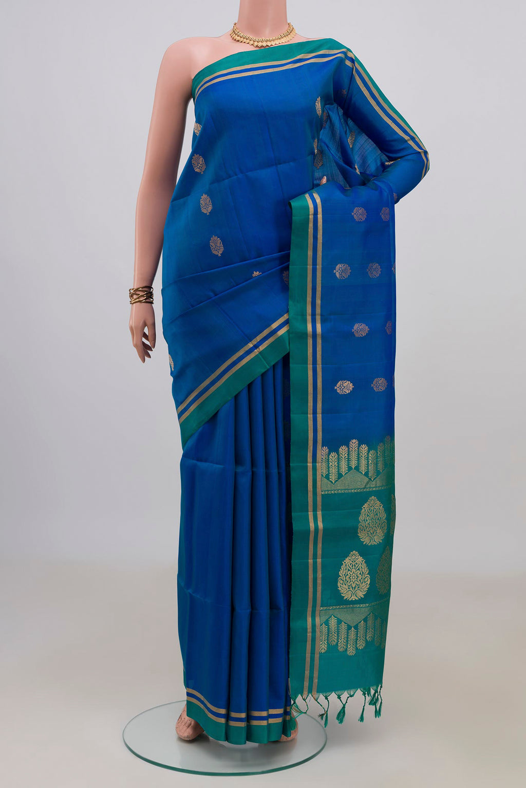 Pure Silk Blue Soft Saree with Zari Butta on the body and Thin Zari Line.  displayed on a mannequin