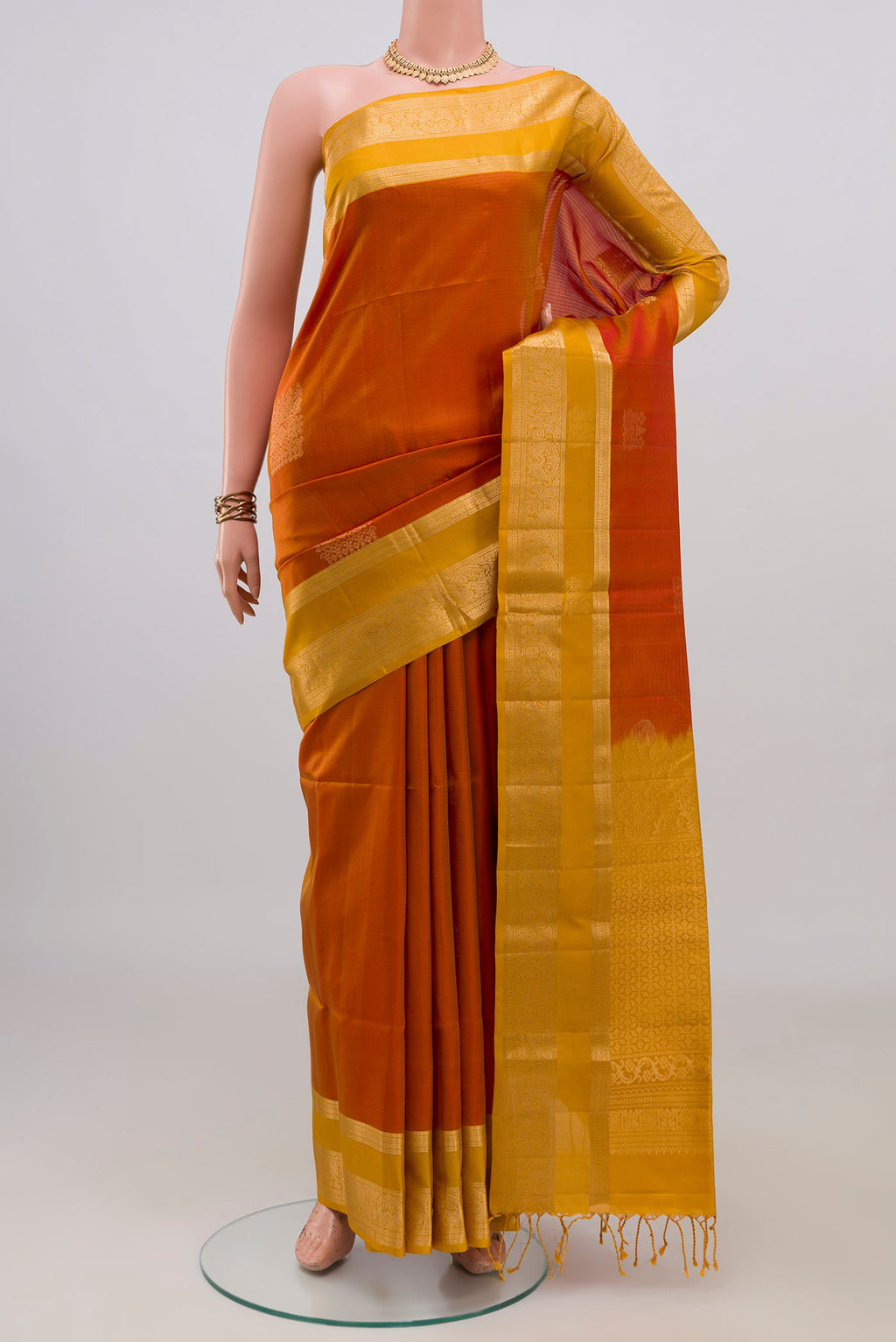 Pure Silk Brick Orange Soft Saree with Zari Butta on the body and Zari Border.  displayed on a mannequin