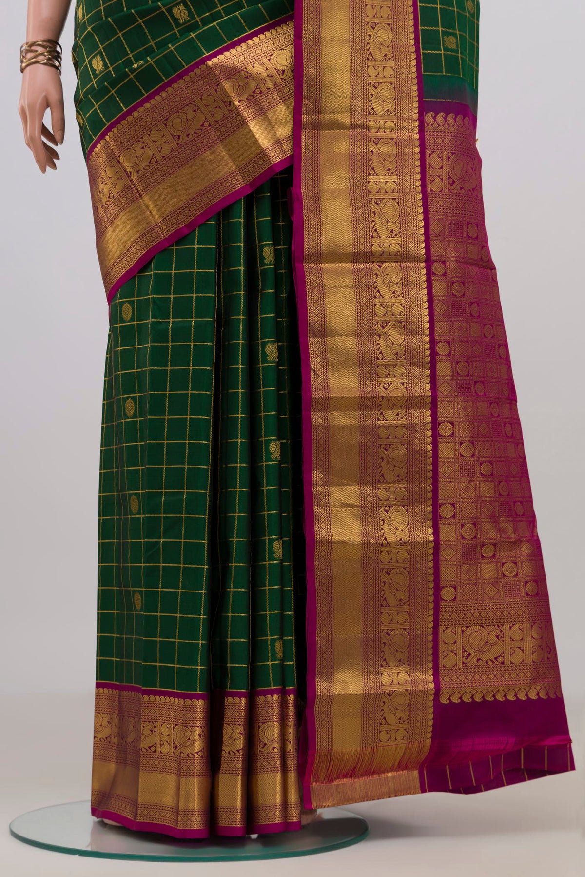 Pleats and pallu of Pure Silk Bottle Green Kanchipuram Saree with Checked design on the body and Zari Border. 