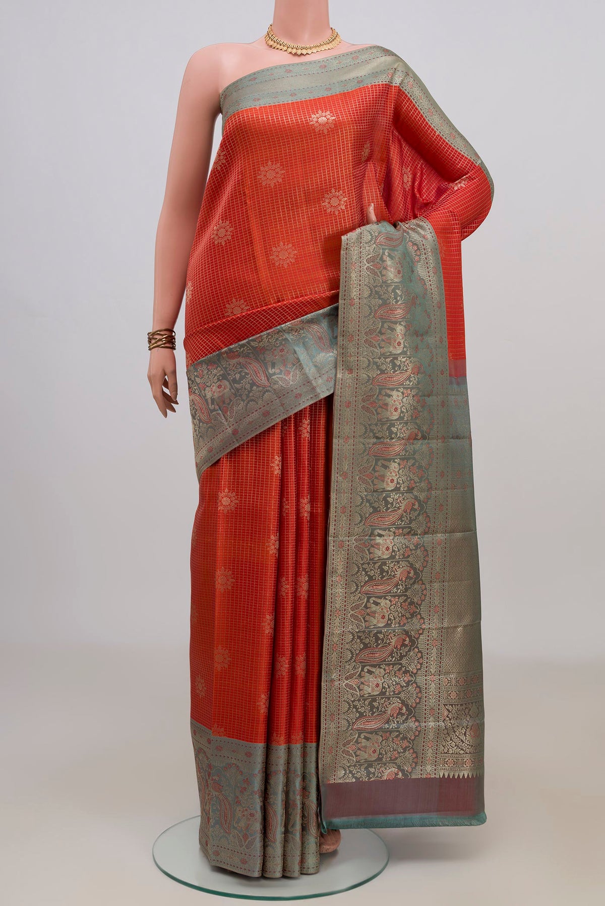 Pure Silk Orange Kanchipuram Saree with Checked design on the body and Fancy Border.  displayed on a mannequin