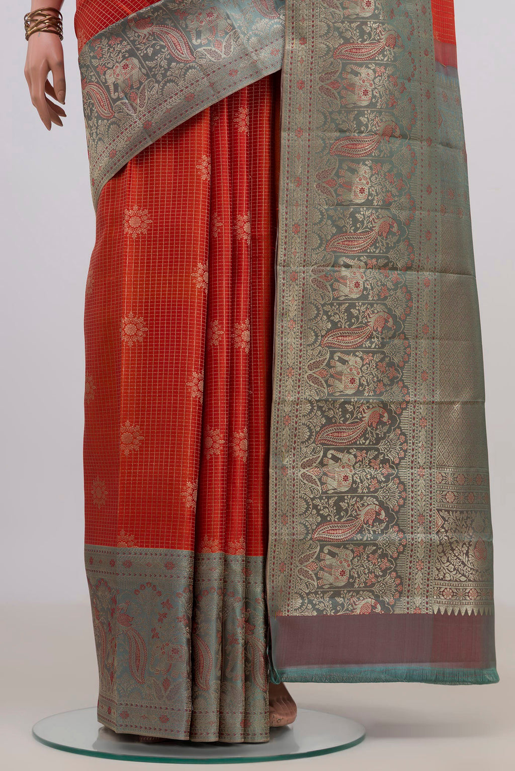 Pleats and pallu of Pure Silk Orange Kanchipuram Saree with Checked design on the body and Fancy Border. 