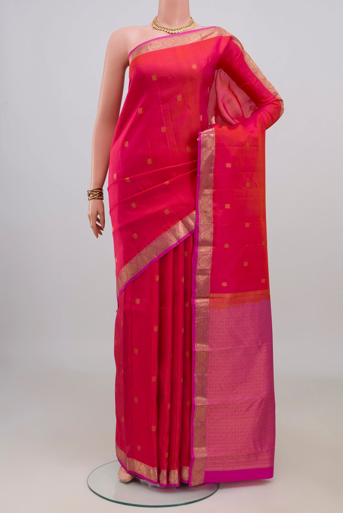 Pure Silk Coral Dual Tone Kanchipuram Saree with Zari Butta on the body and Zari Border.  displayed on a mannequin