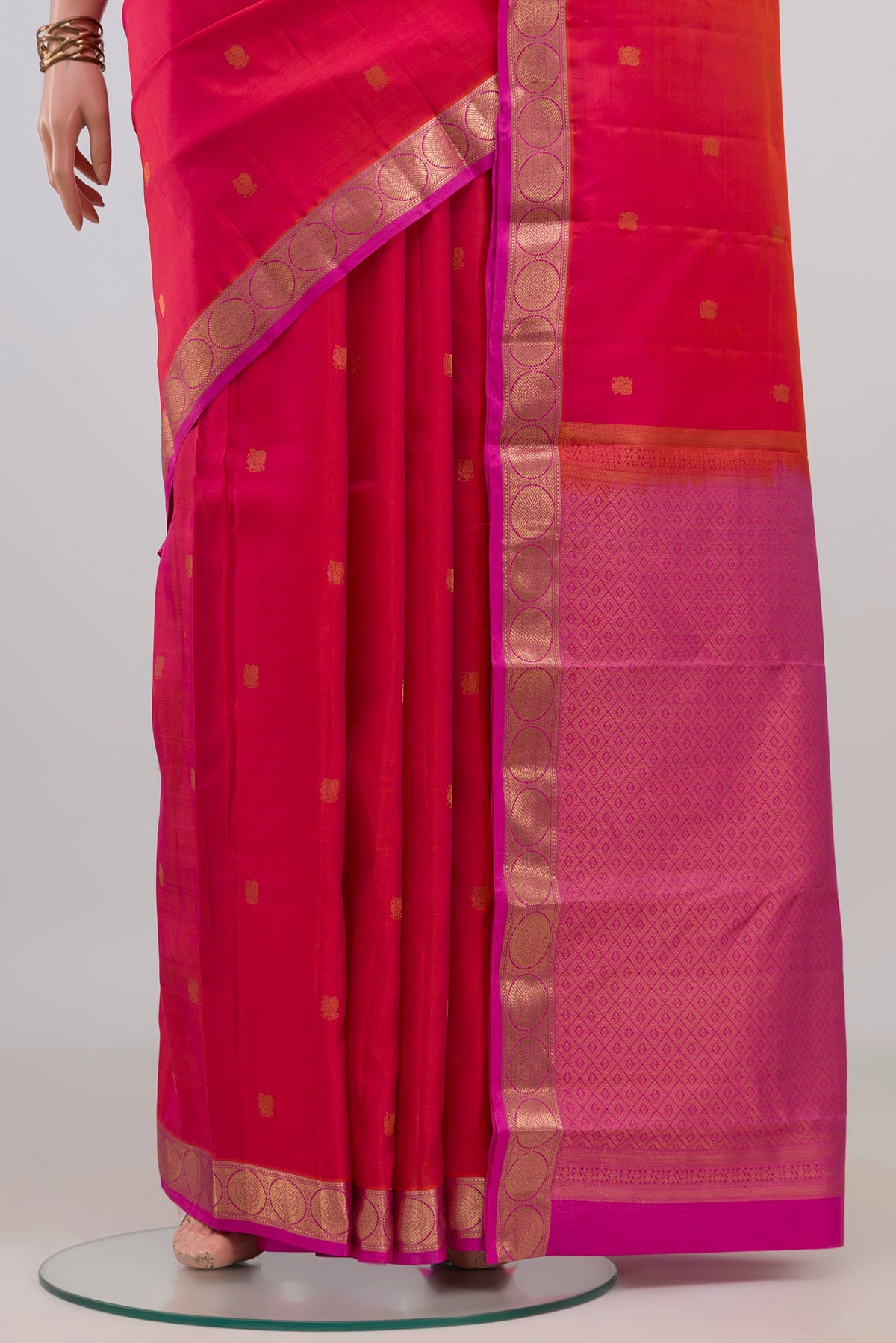 Pleats and pallu of Pure Silk Coral Dual Tone Kanchipuram Saree with Zari Butta on the body and Zari Border. 