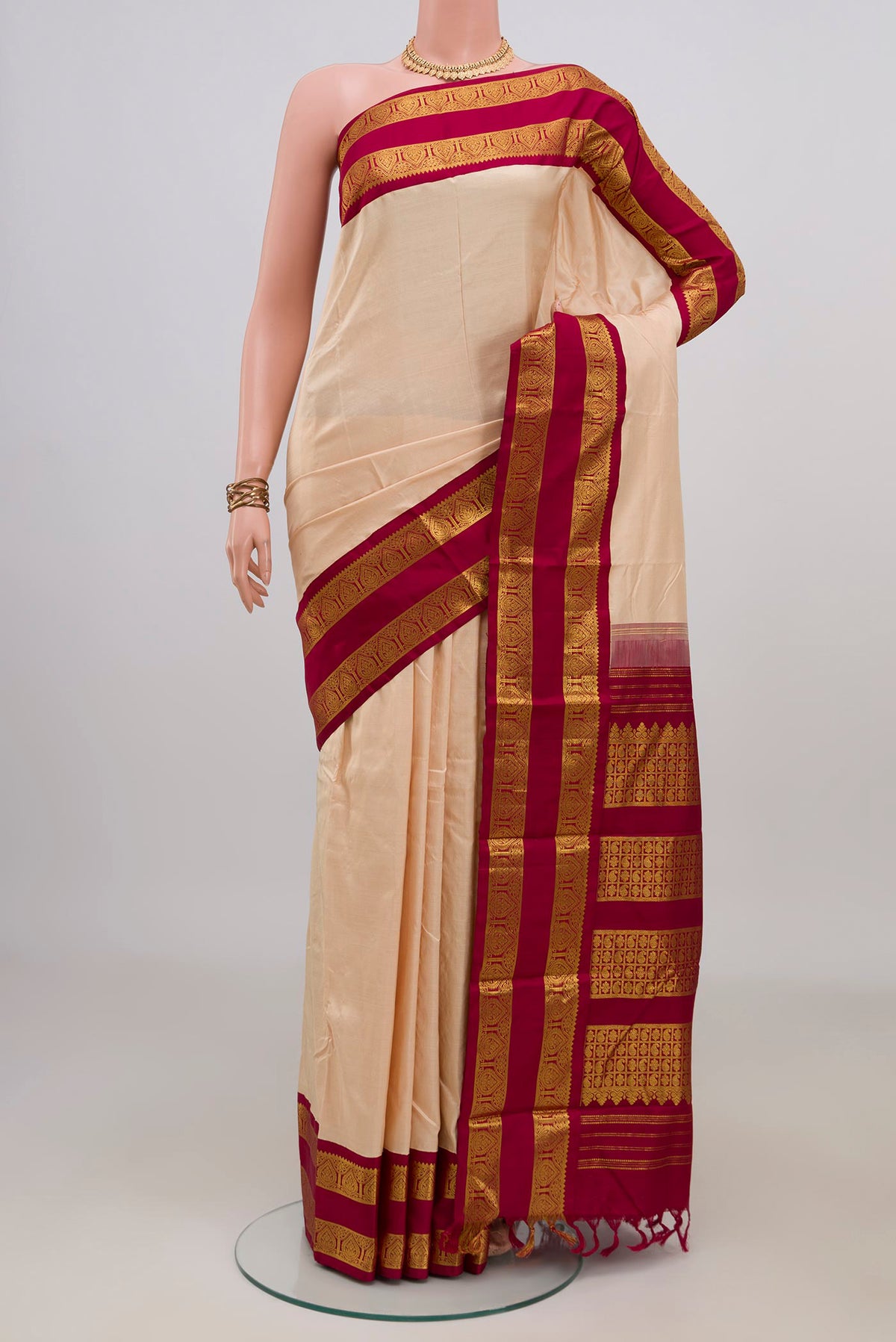 Pure Silk Cream Kanjivaram Saree with Plain Body and Zari Border.  displayed on a mannequin
