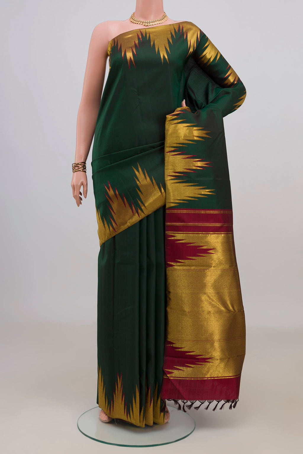 Pure Silk Bottle Green Kanjivaram Saree with Plain Body and Temple Border.  displayed on a mannequin