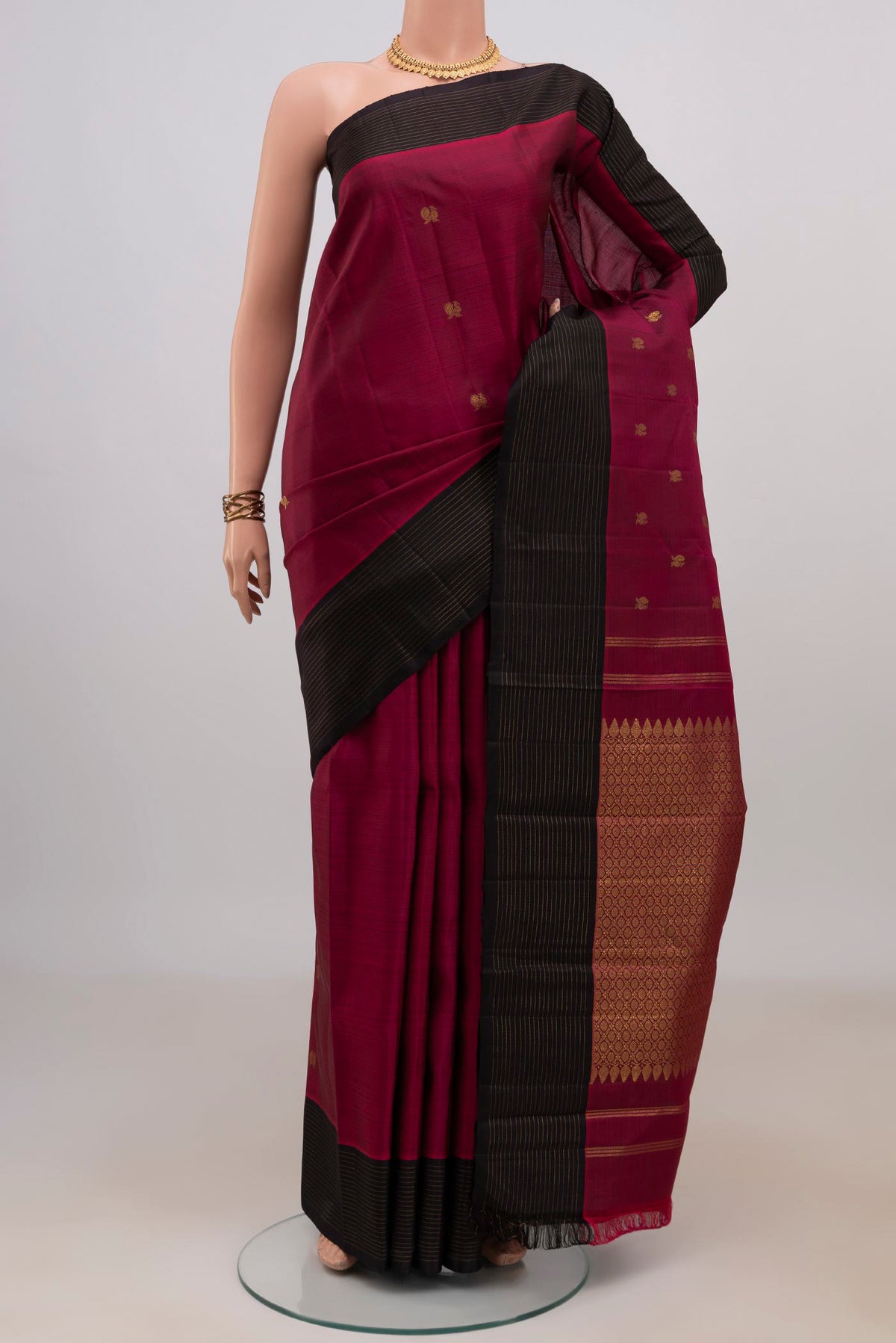 Pure Silk Pure Zari Maroon Kanchipuram Saree with Zari Butta on the body and Plain Border.  displayed on a mannequin