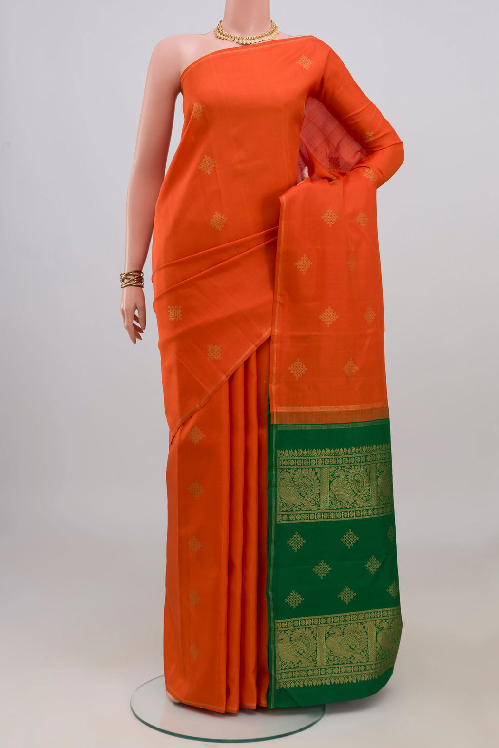 Pure Silk Pure Zari Orange Kanchipuram Saree with Zari Butta on the body and Thin Zari Line.  displayed on a mannequin