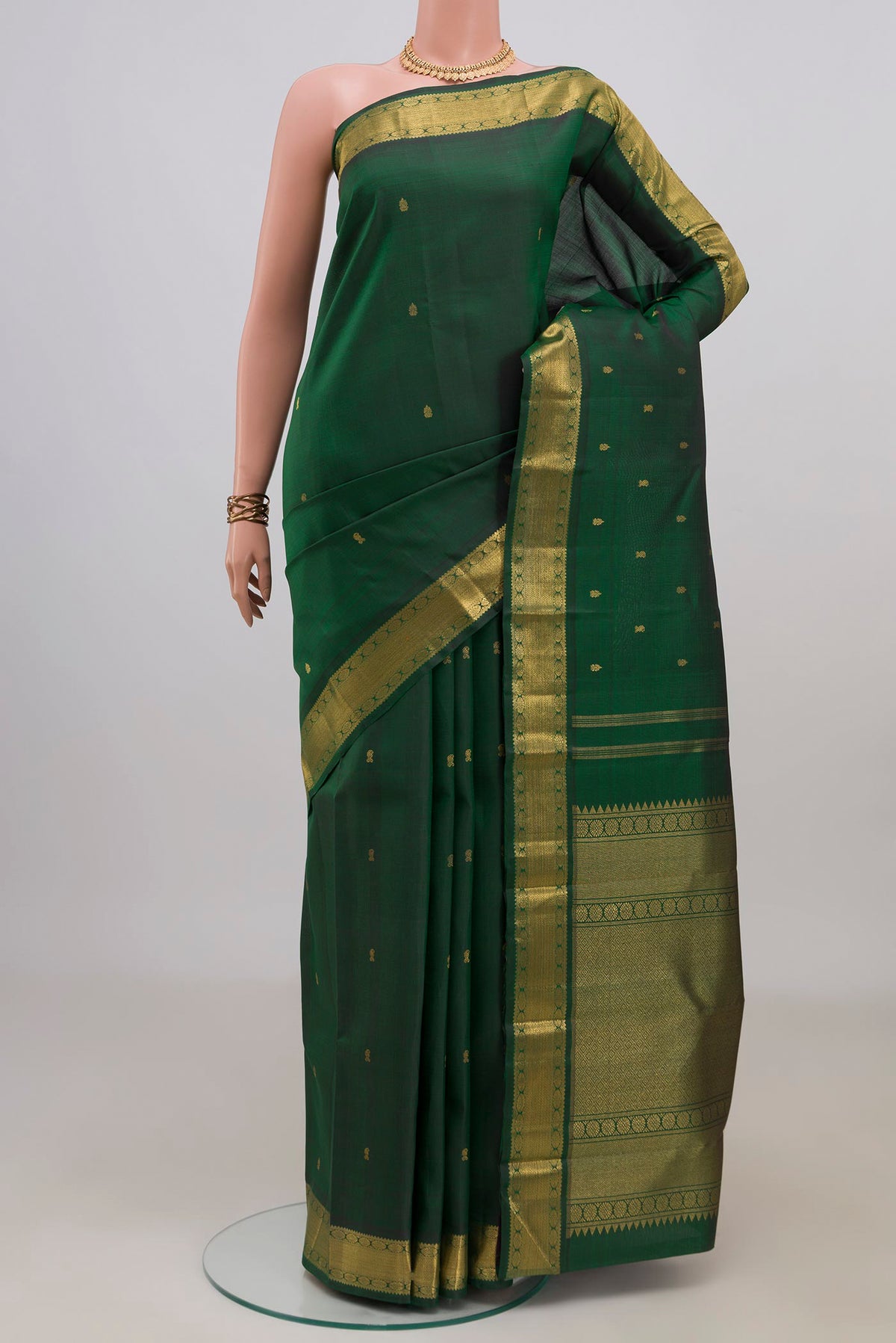 Pure Silk Pure Zari Bottle Green Kanjivaram Saree with Zari Butta on the body and Zari Border.  displayed on a mannequin