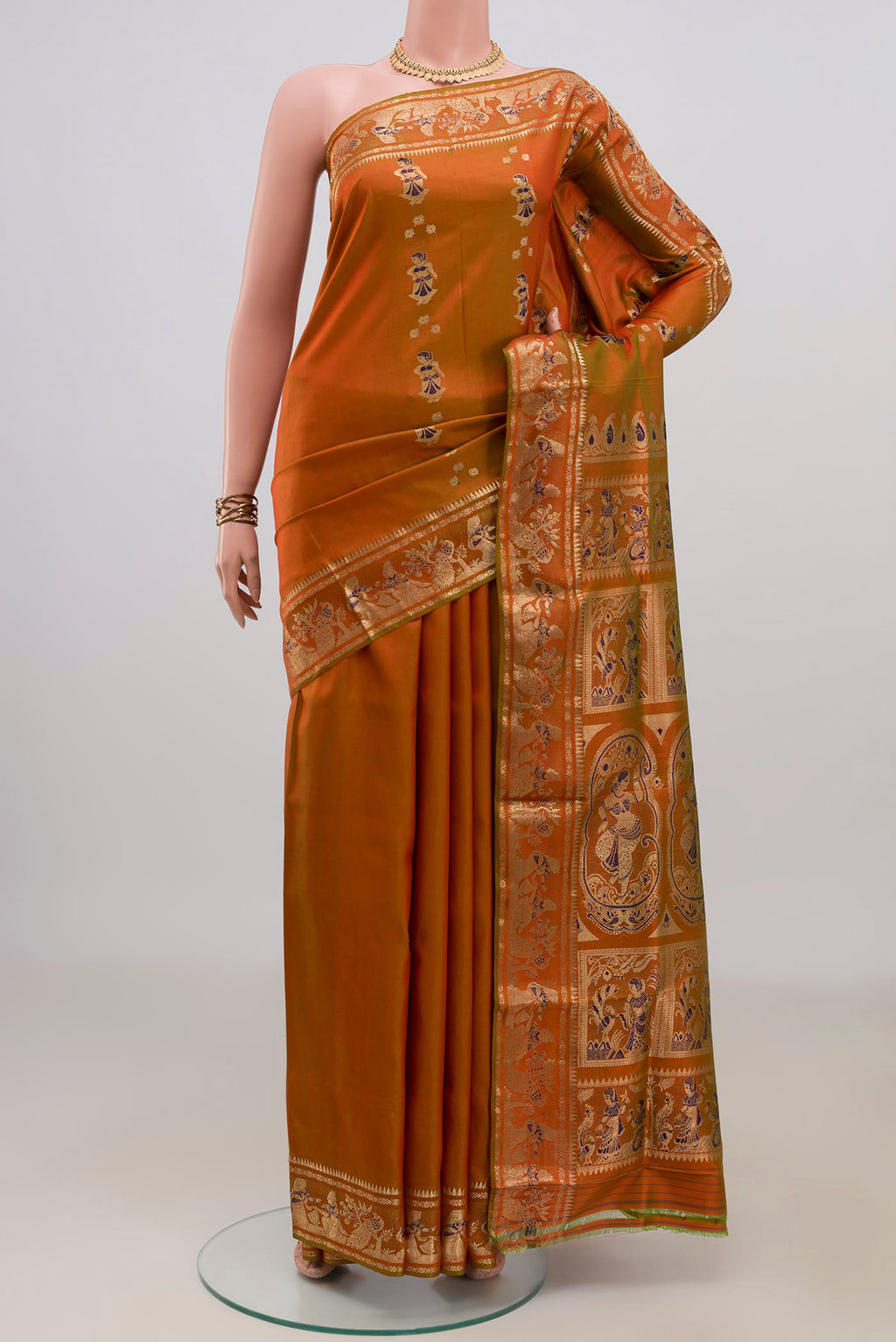 Pure Silk Rust Baluchari Saree with Zari And Thread Butta on the body and Fancy Border.  displayed on a mannequin