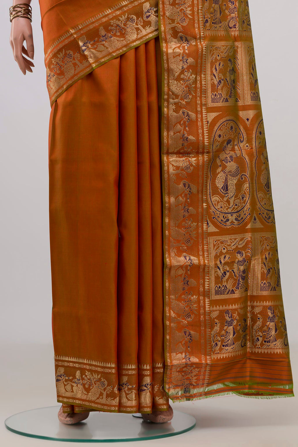 Pleats and pallu of Pure Silk Rust Baluchari Saree with Zari And Thread Butta on the body and Fancy Border. 