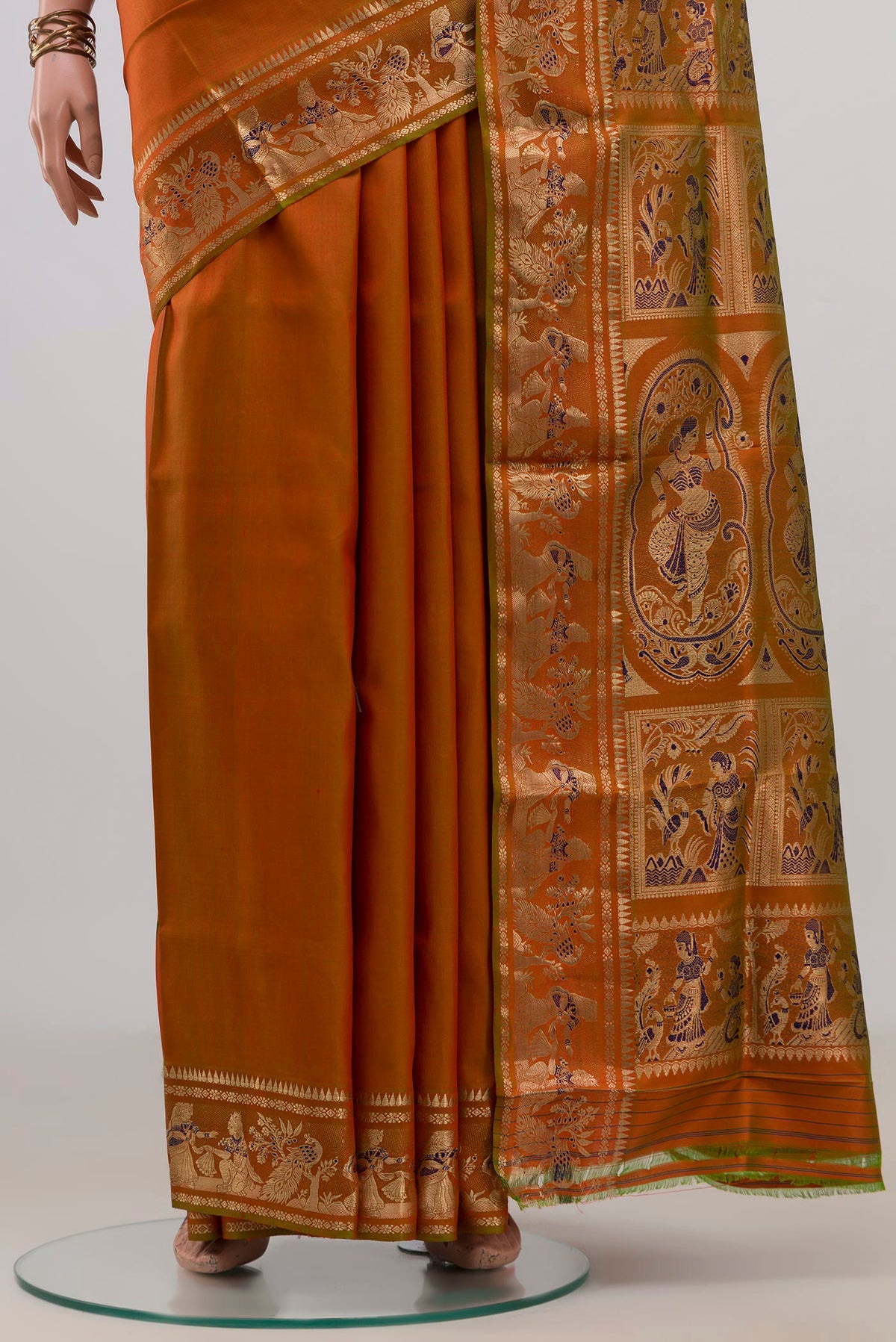 Pleats and pallu of Pure Silk Rust Baluchari Saree with Zari And Thread Butta on the body and Fancy Border. 
