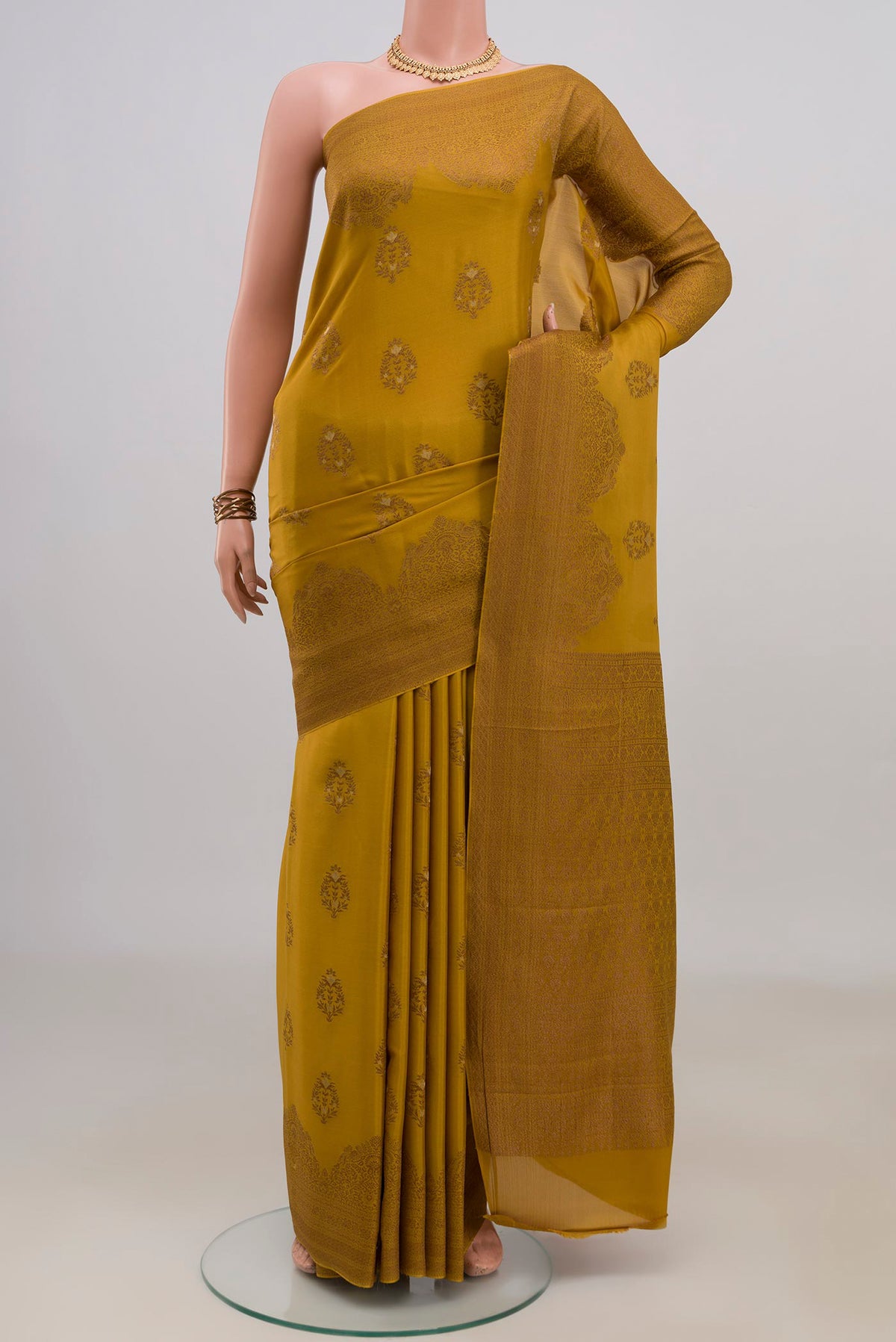 Mustard Crepe Saree with Zari Butta on the body and Fancy Border.  displayed on a mannequin