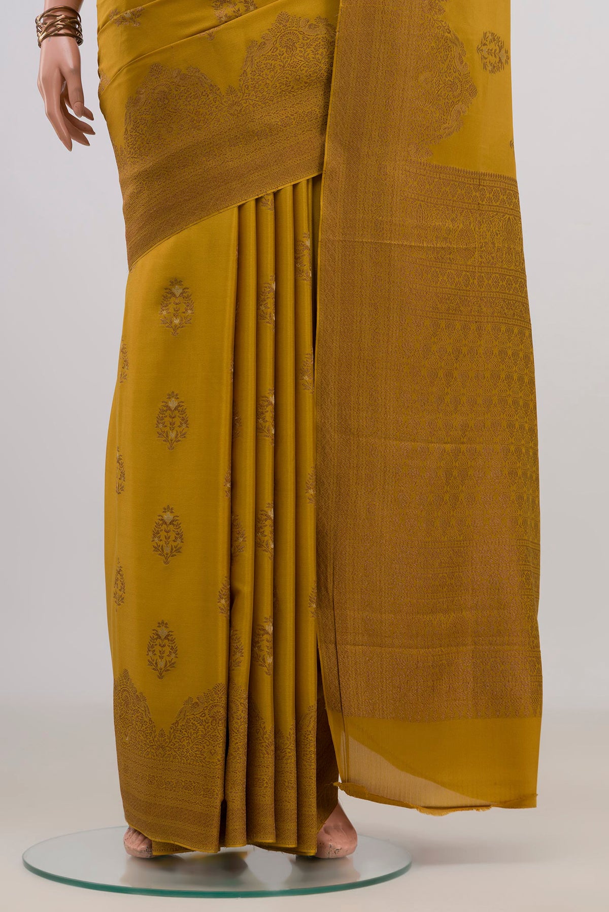 Pleats and pallu of Mustard Crepe Saree with Zari Butta on the body and Fancy Border. 