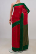 Red Crepe Saree with Zari Butta on the body and Thin Zari Line.  displayed on a mannequin
