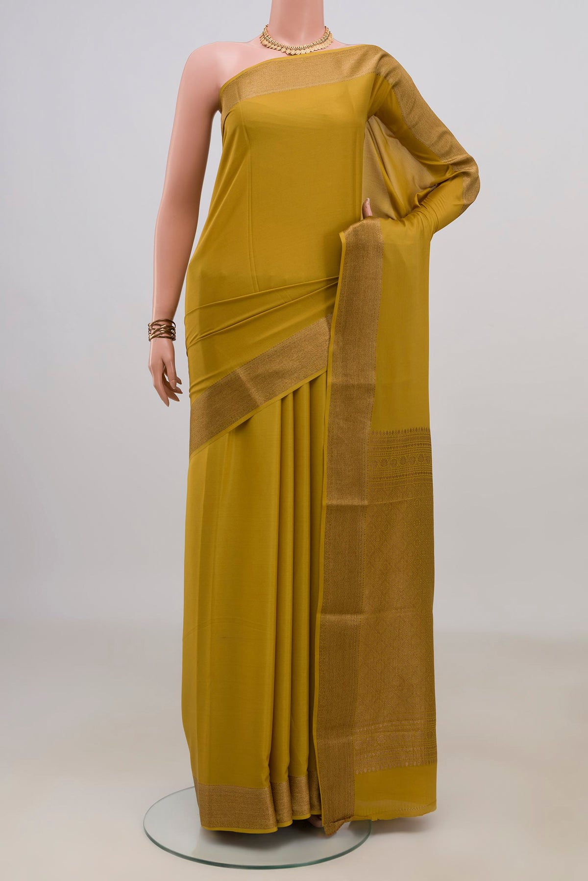 Mustard Crepe Saree with Plain Body and Zari Border.  displayed on a mannequin