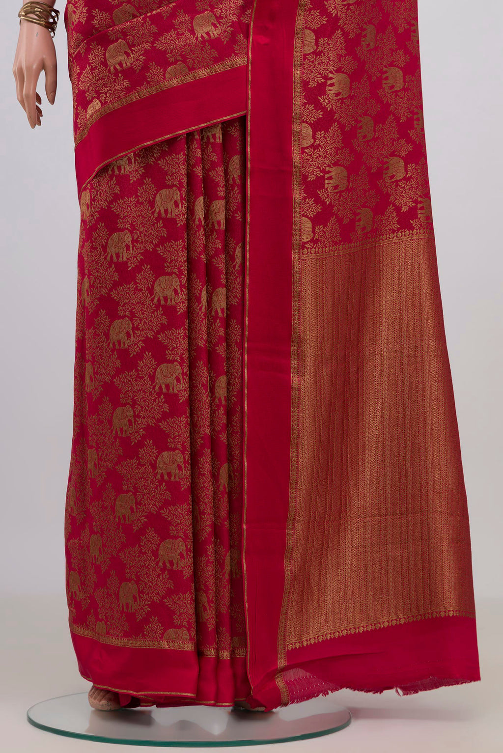 Pleats and pallu of Red Crepe Saree with Fancy on the body and Thin Zari Line. 