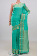 Pure Silk Turquoise Kanchipuram Saree with Zari Butta on the body and Zari Border.  displayed on a mannequin