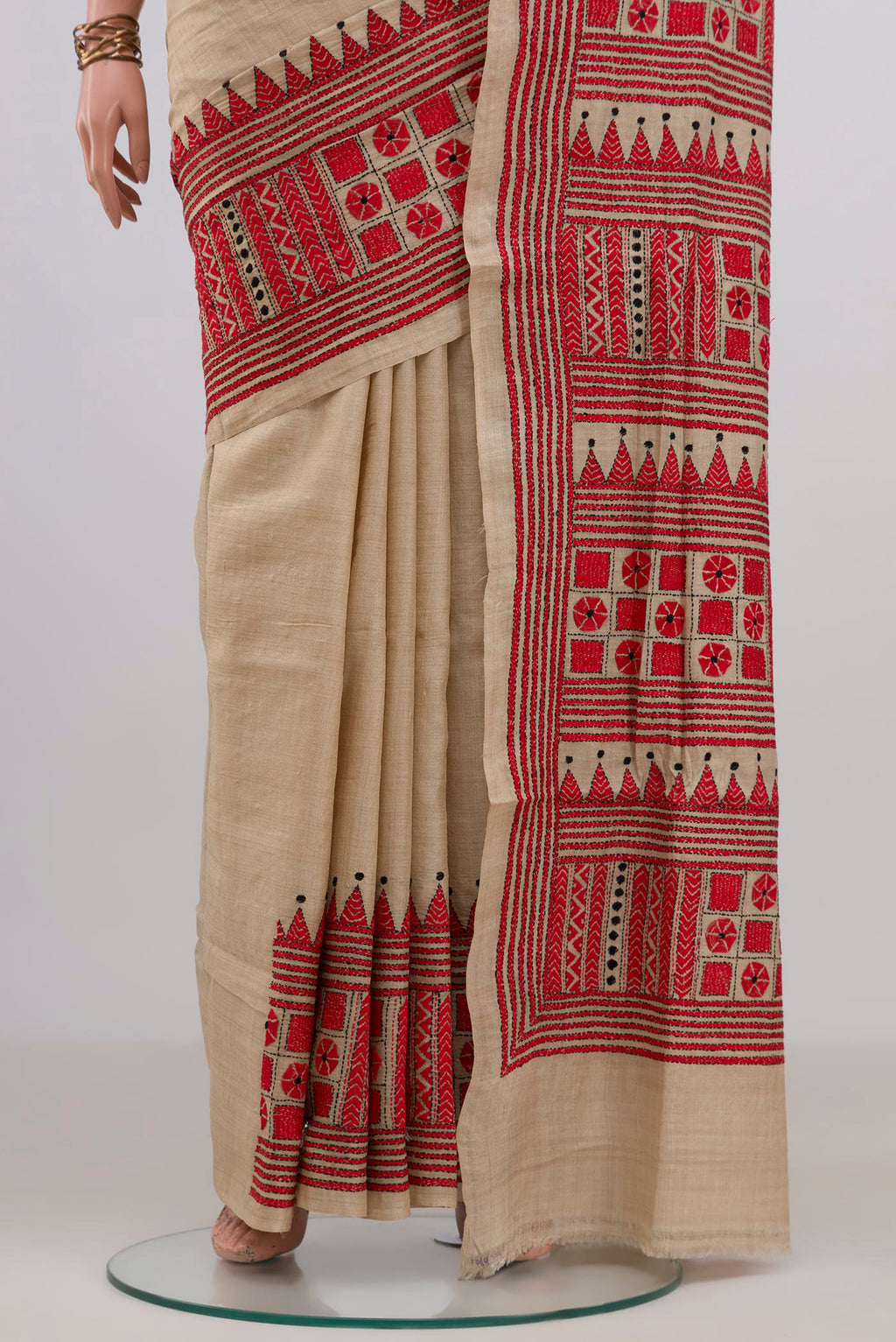 Pleats and pallu of Beige Tussar Saree with Kantha Work on the body and Embroidery Border. 