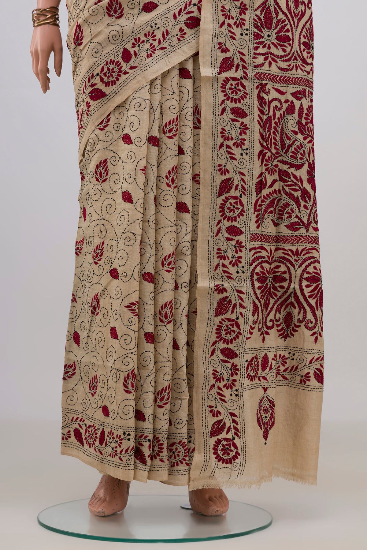 Pleats and pallu of Beige Tussar Saree with Kantha Work on the body and Embroidery Border. 