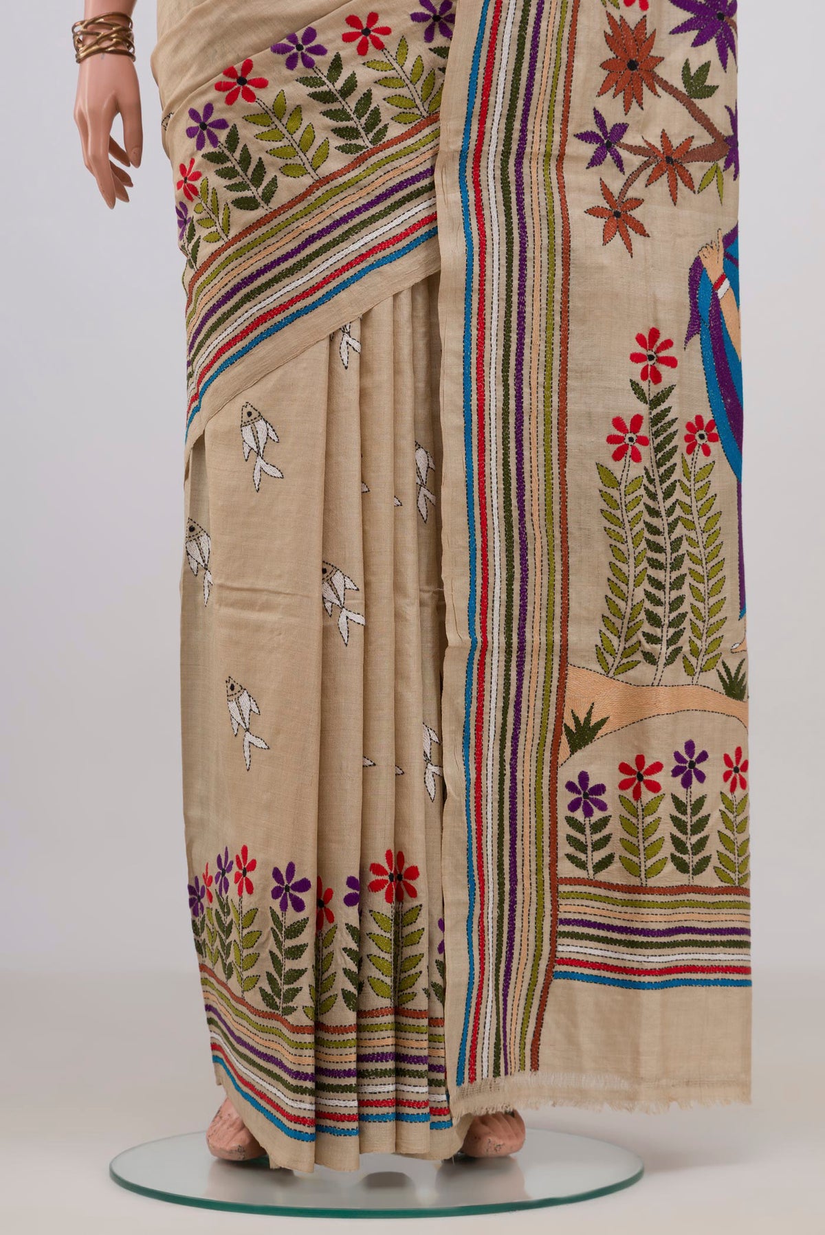 Pleats and pallu of Beige Tussar Saree with Kantha Work on the body and Embroidery Border. 