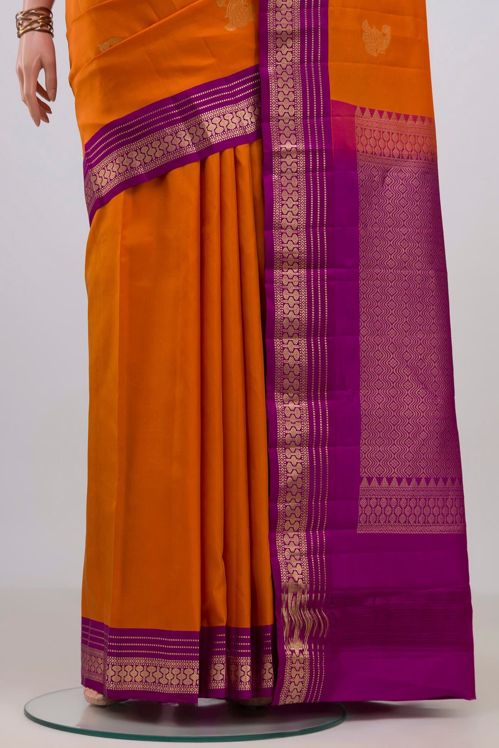 Pleats and pallu of Pure Silk Orange Kanchipuram Saree with Zari Butta on the body and Zari Border. 