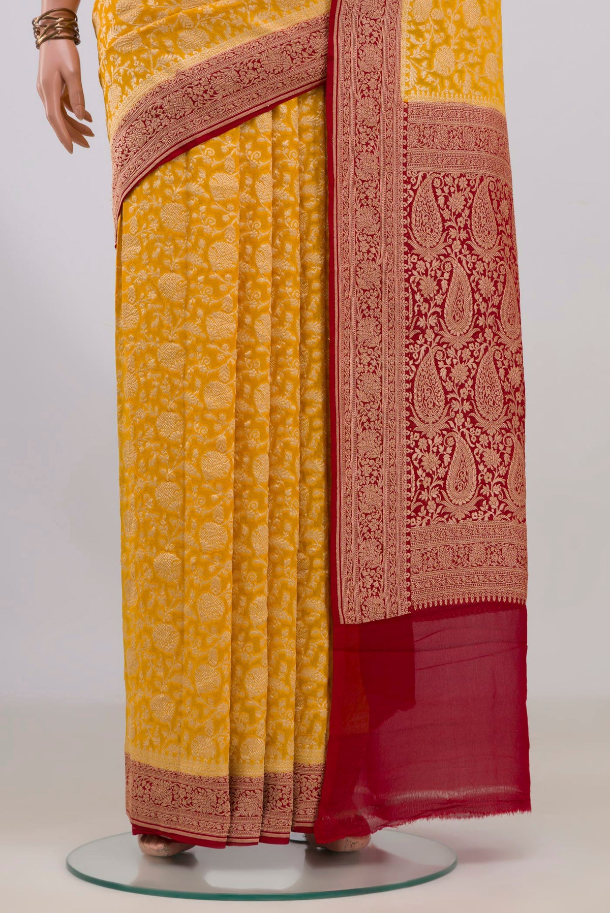 Pleats and pallu of Yellow Banarasi Georgette Saree with Zari Brocade on the body and Fancy Border. 