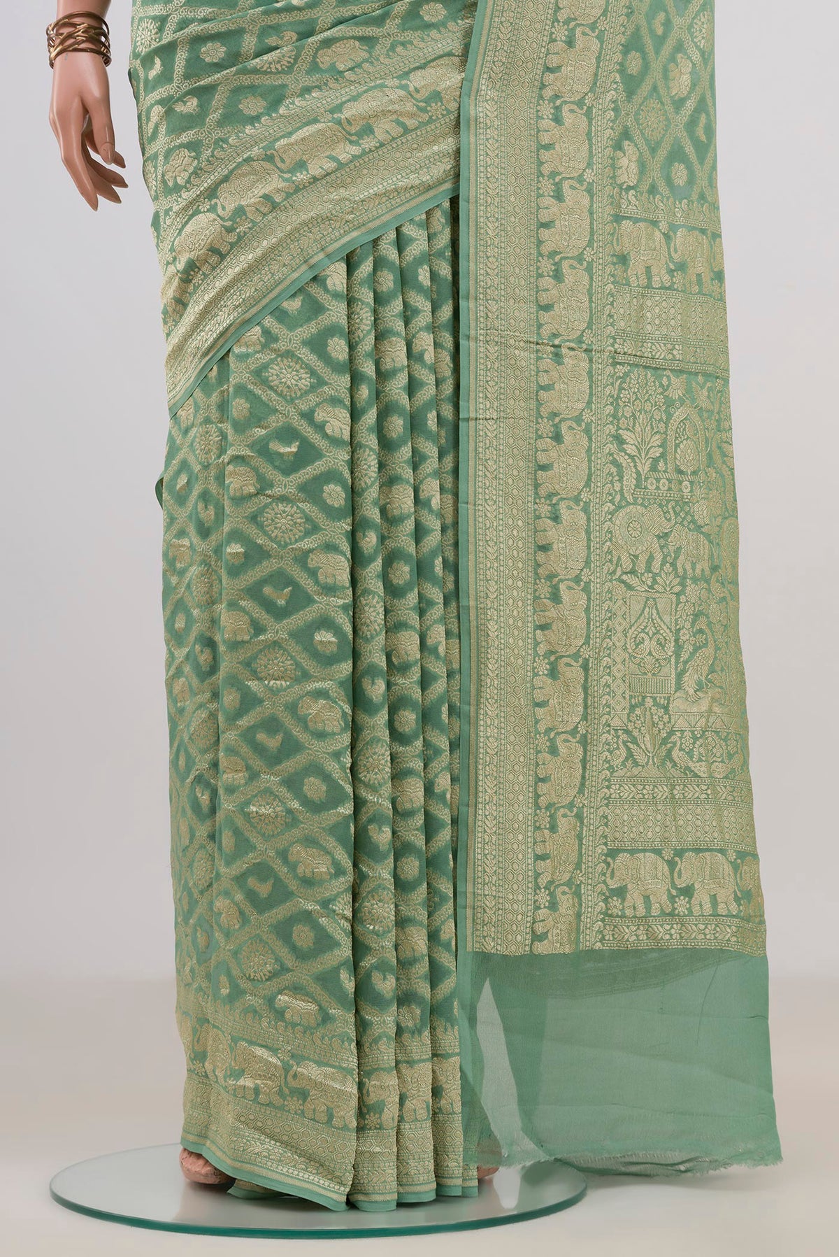 Pleats and pallu of Pista Green Banarasi Georgette Saree with Zari Brocade on the body and Fancy Border. 