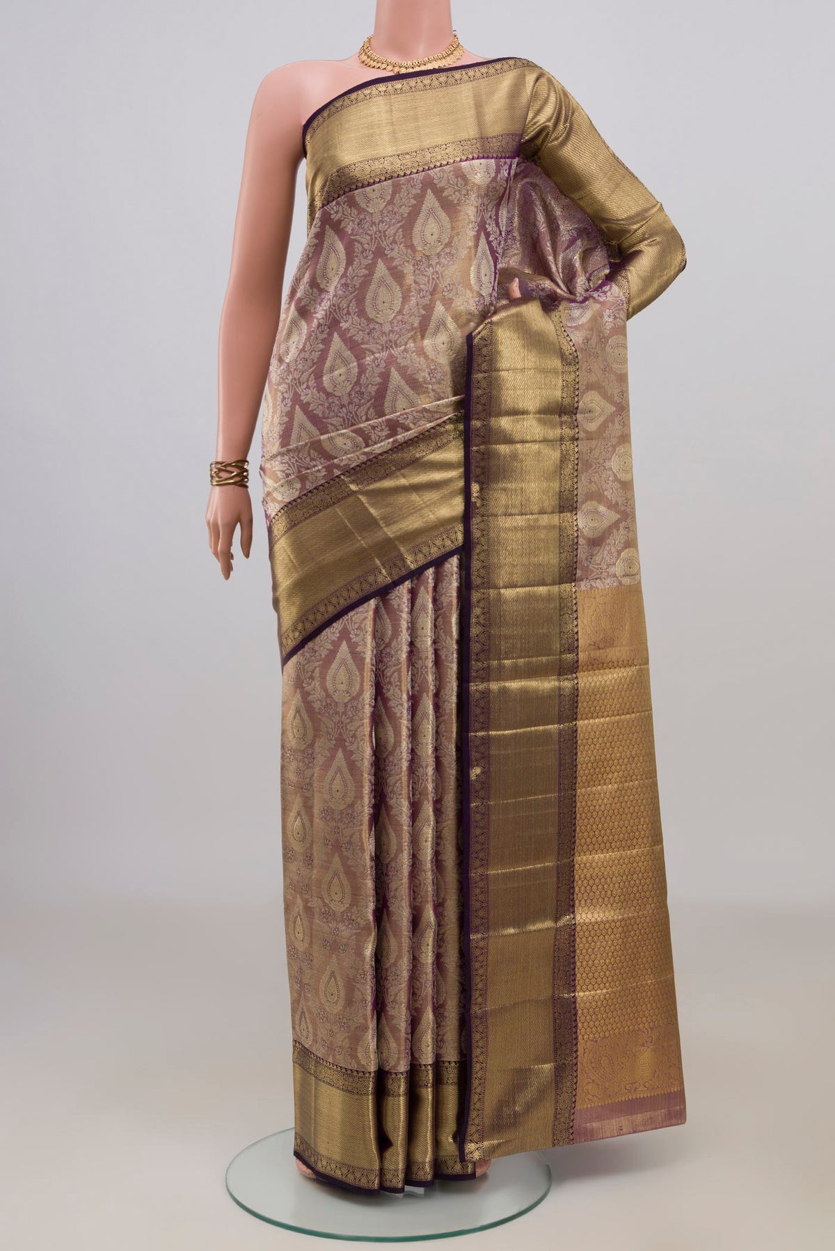 Gold with Purple Color Kanjivaram Tissue Saree with Zari Brocade on the body and Zari Border.  displayed on a mannequin