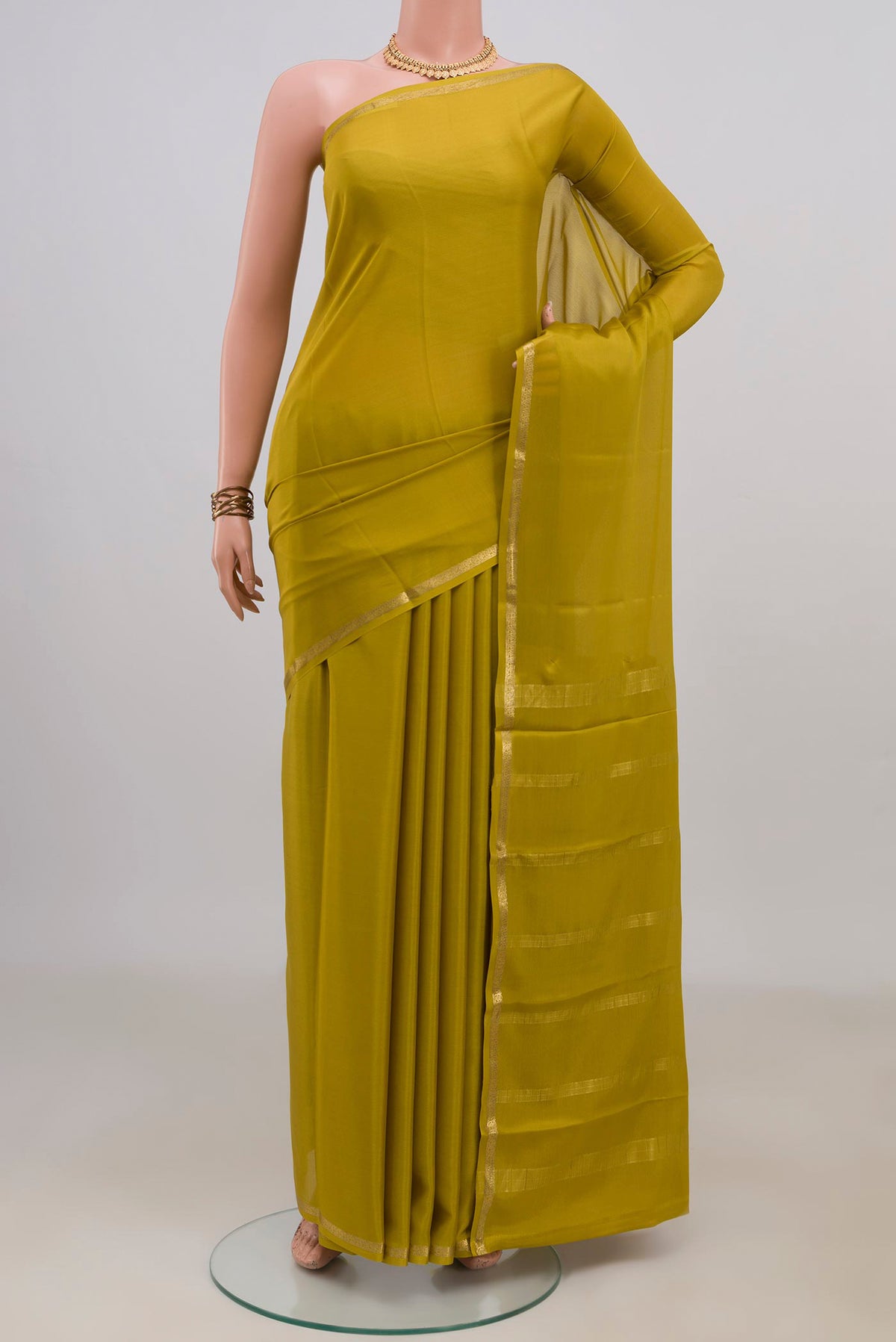 Mehandi Green Mysore Crepe Saree with Plain Body and Thin Zari Line.  displayed on a mannequin