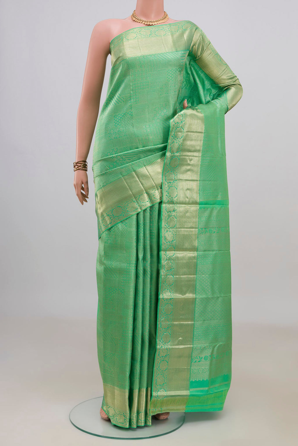 Pure Silk Green Kanjivaram Saree with Zari Brocade on the body and Zari Border.  displayed on a mannequin