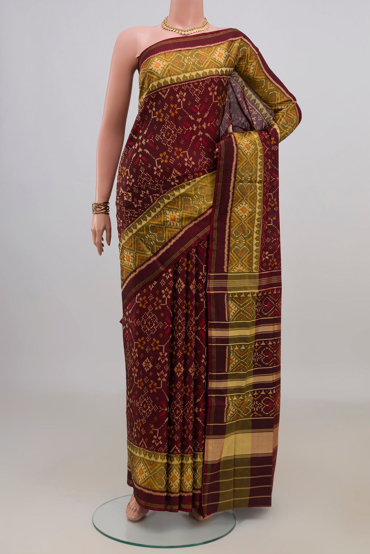 Pure Silk Coffee Brown Rajkot Patola Saree with Ikat design on the body and Ikat Border.  displayed on a mannequin