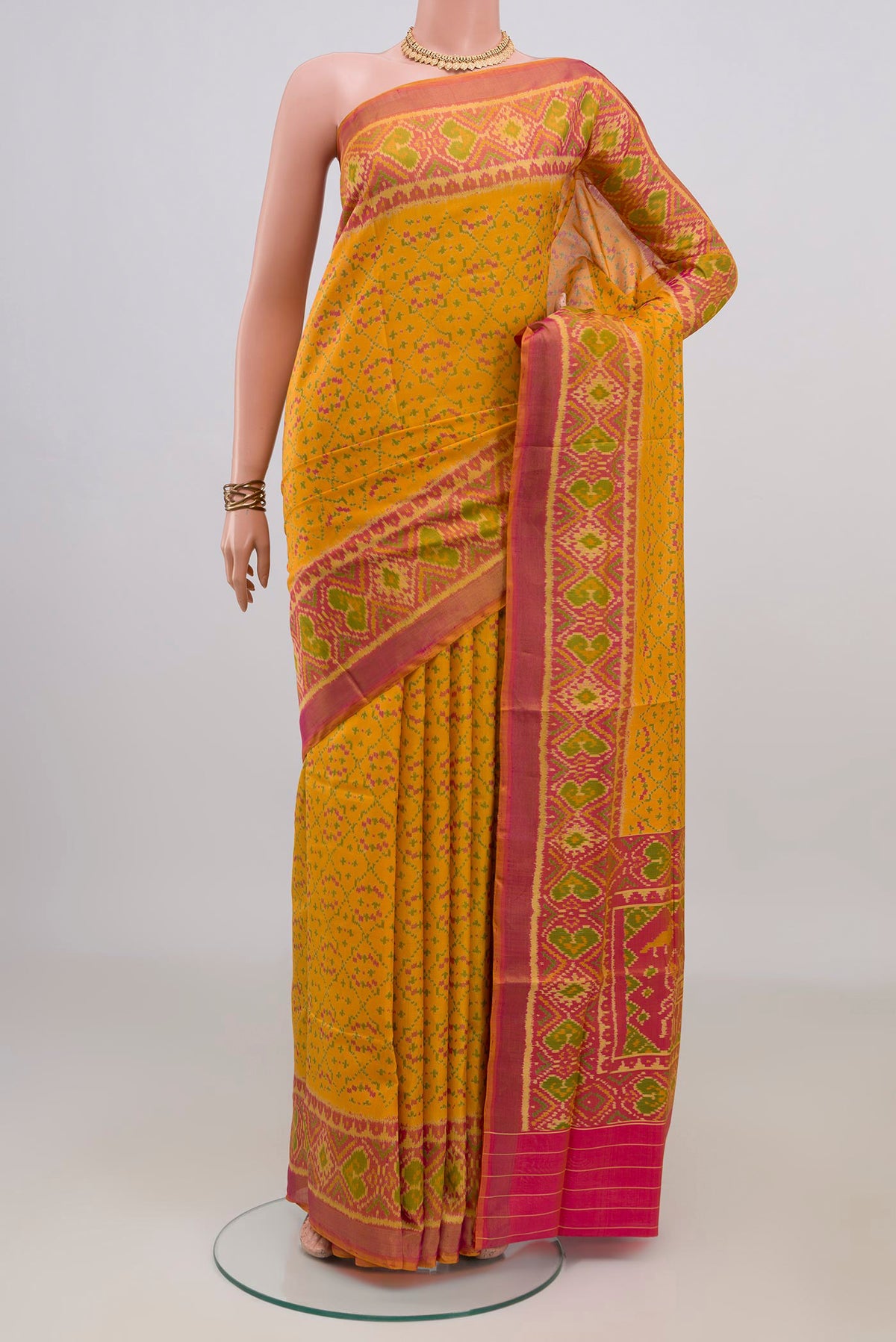 Pure Silk Yellow Rajkot Patola Saree with Pure Ikat on the body and Ikat Border.  displayed on a mannequin