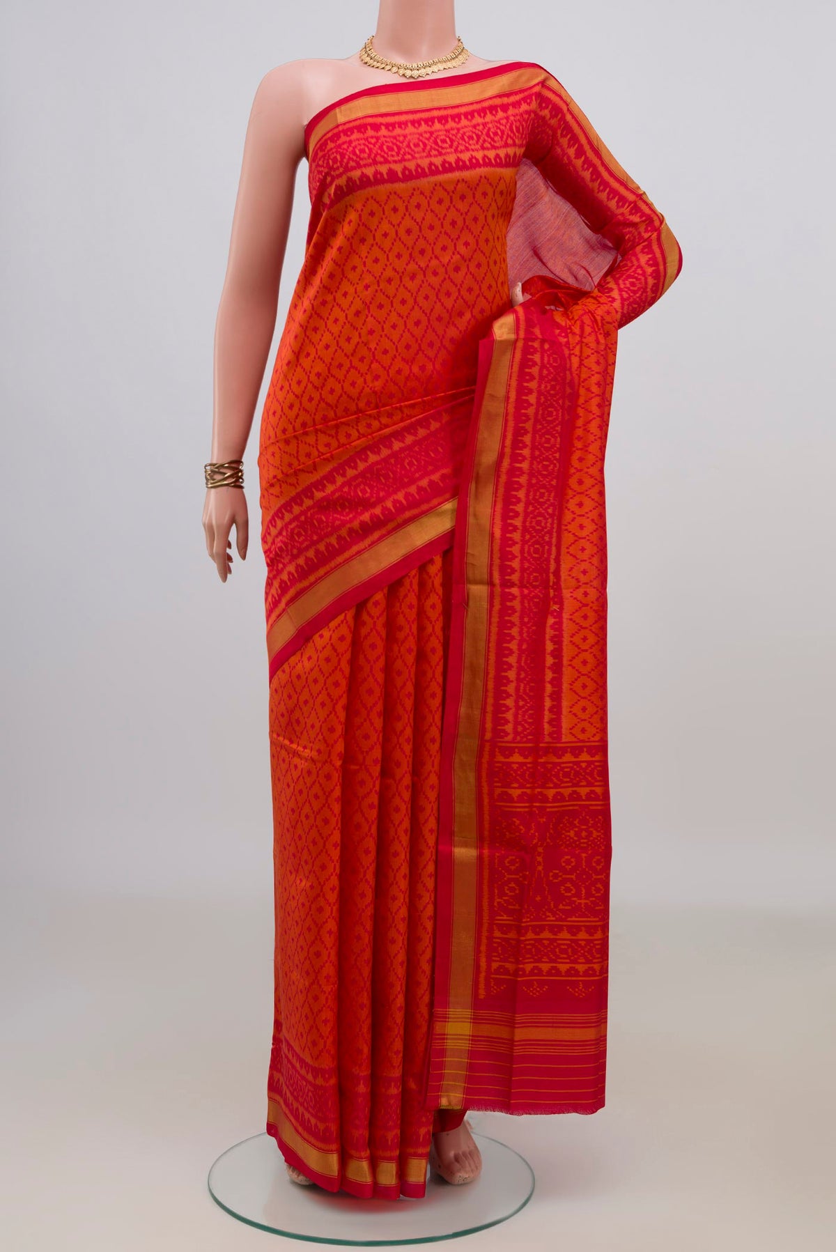 Pure Silk Orange Rajkot Patola Saree with Ikat design on the body and Thin Zari Line.  displayed on a mannequin