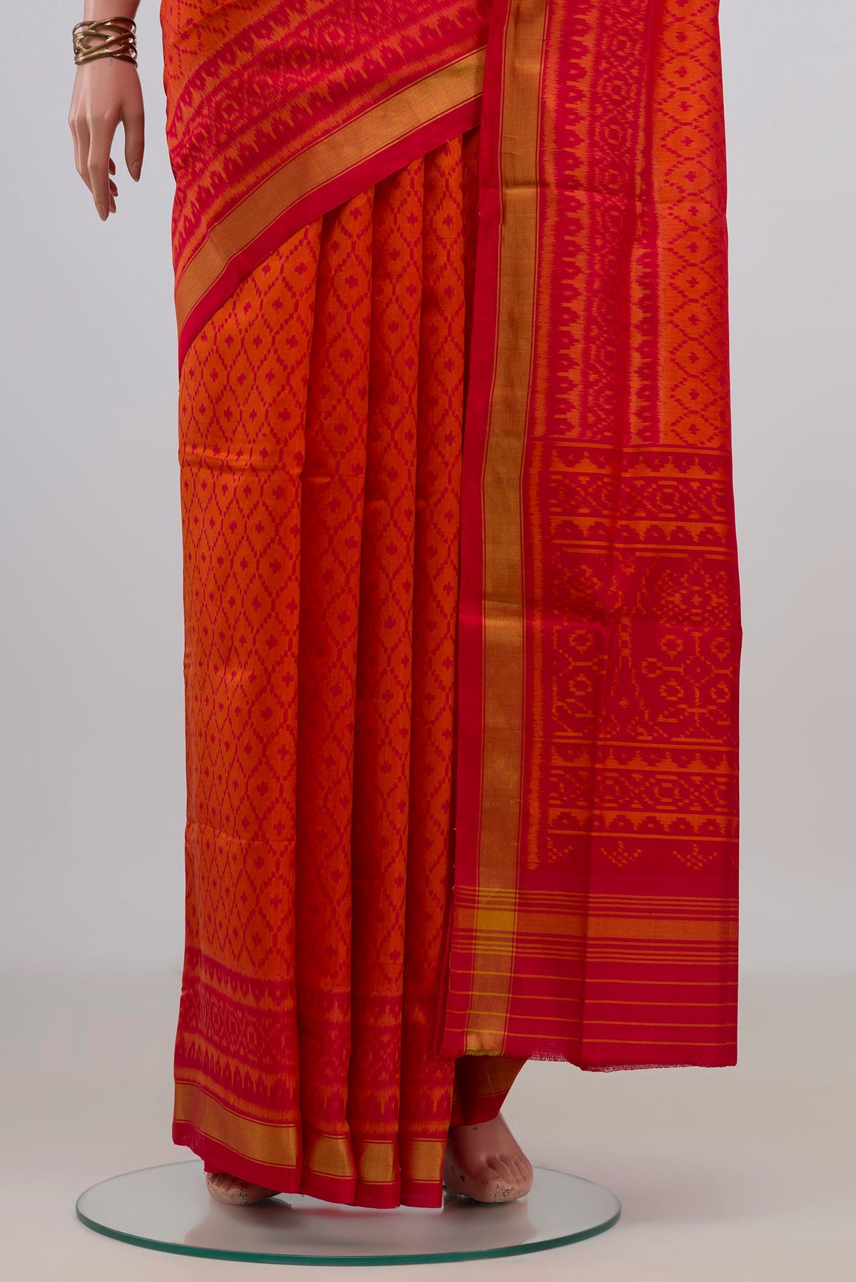 Pleats and pallu of Pure Silk Orange Rajkot Patola Saree with Ikat design on the body and Thin Zari Line. 
