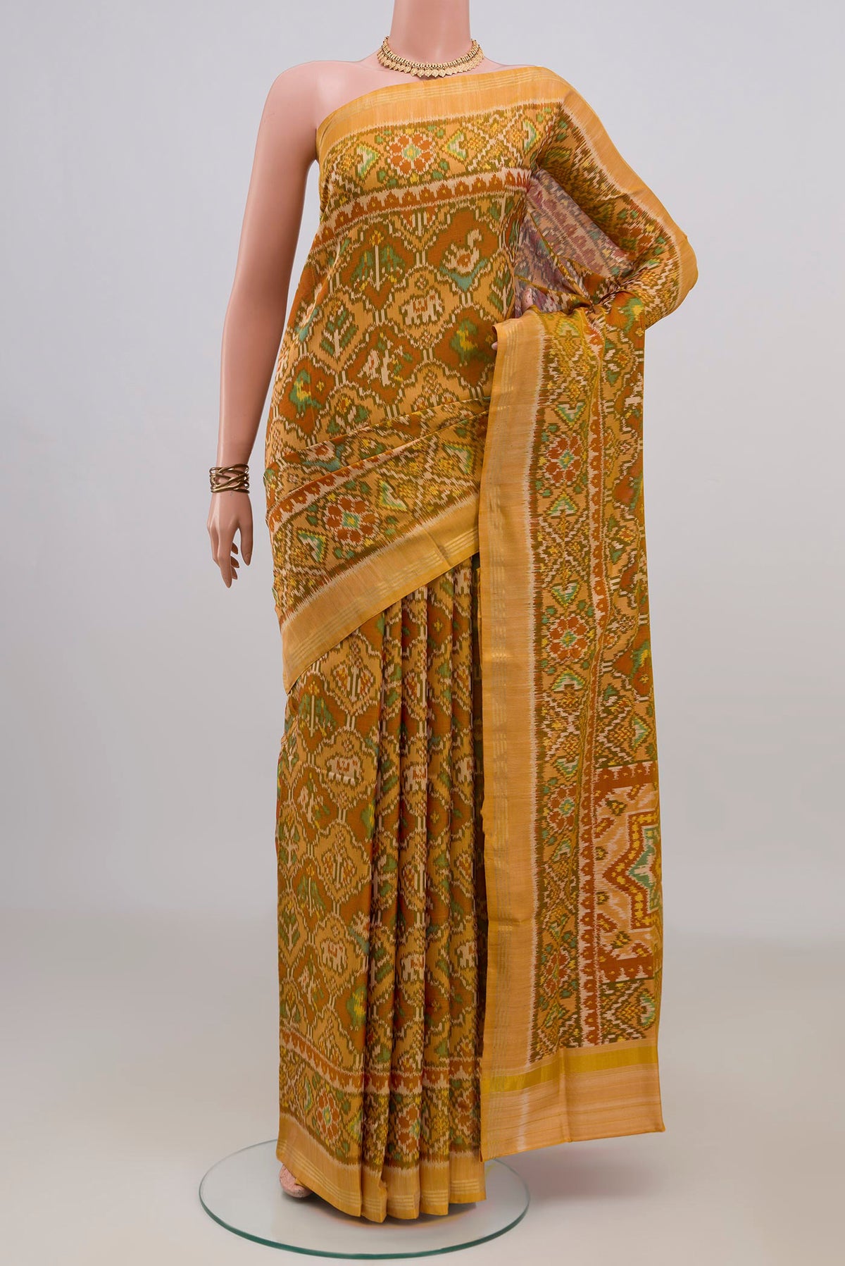 Pure Silk Mustard Rajkot Patola Saree with Pure Ikat on the body and Thin Zari Line.  displayed on a mannequin