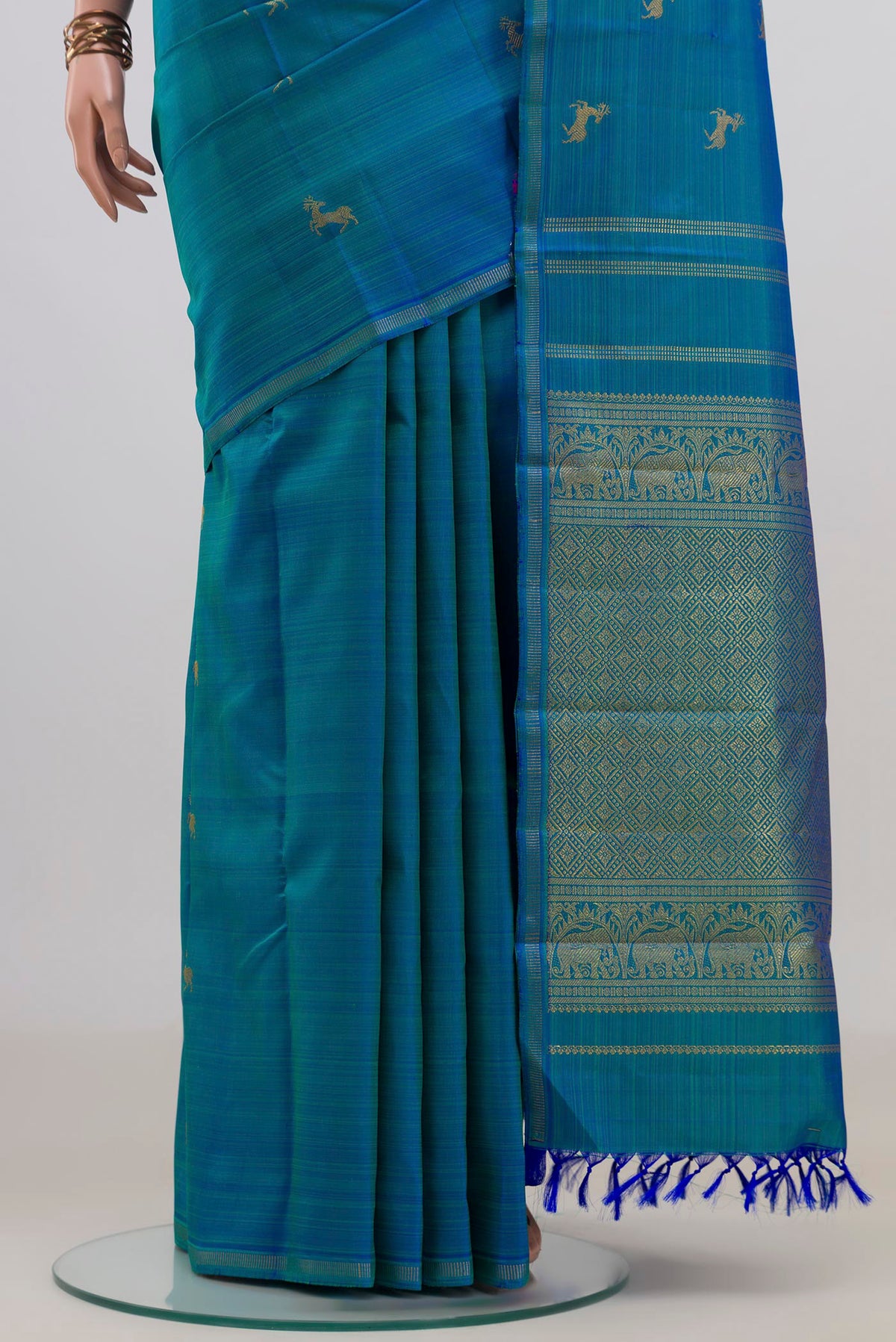 Pleats and pallu of Pure Silk Pure Zari Blue Kanchipuram Saree with Zari Butta on the body and Thin Zari Line. 