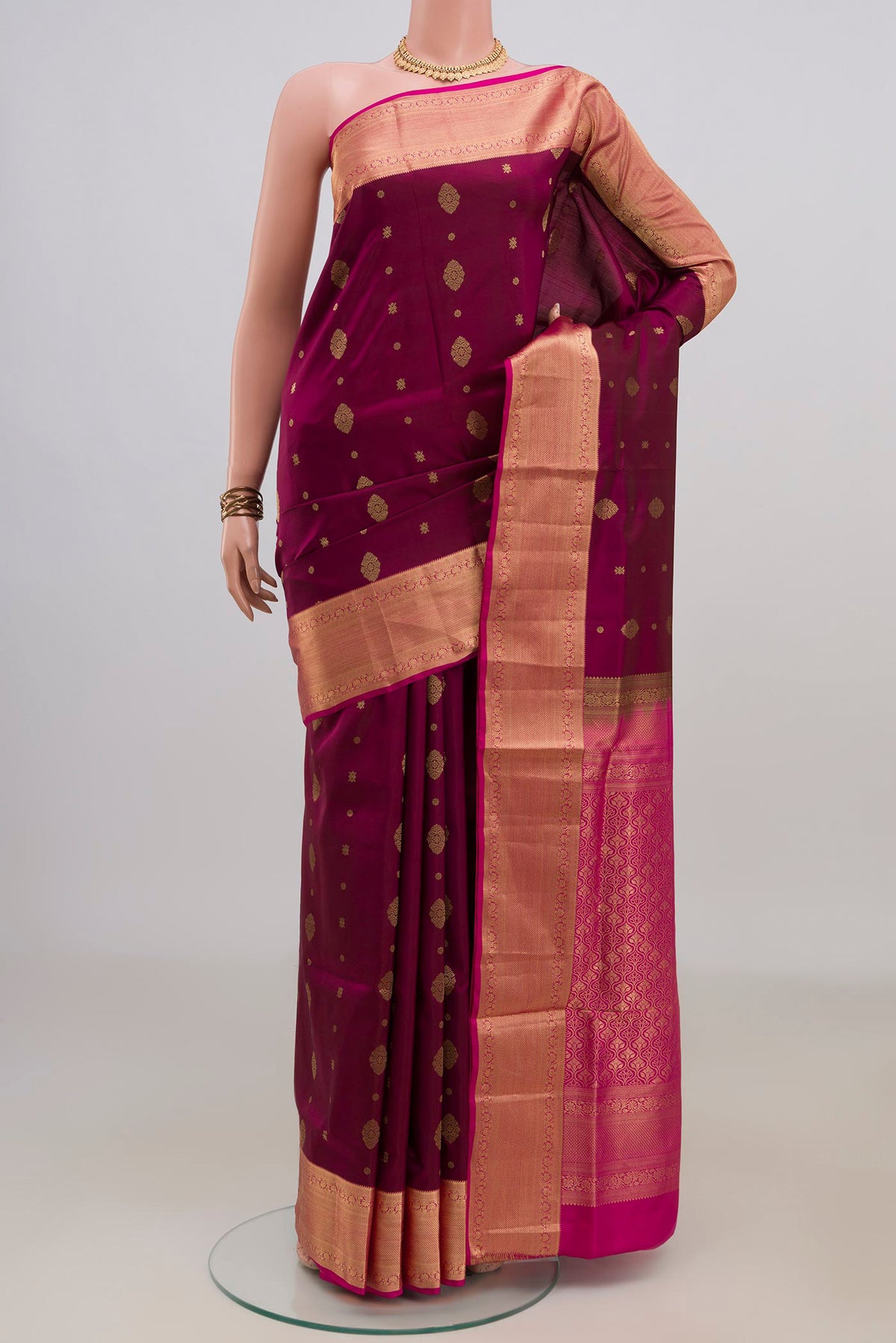 Pure Silk Magenta Soft Saree with Zari Butta on the body and Zari Border.  displayed on a mannequin