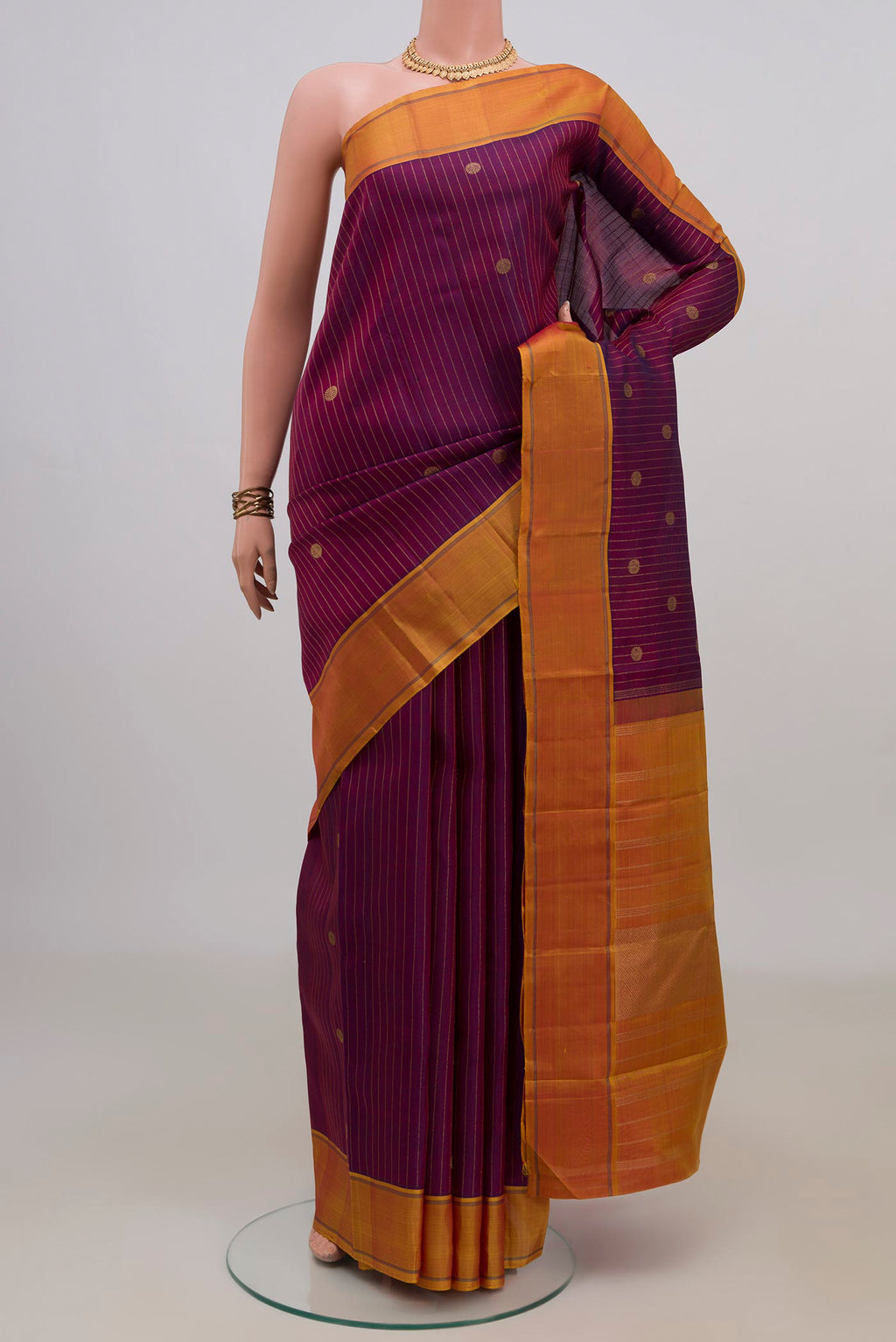 Pure Silk Pure Zari Purple Kanchipuram Saree with Zari Butta on the body and Thin Zari Line.  displayed on a mannequin