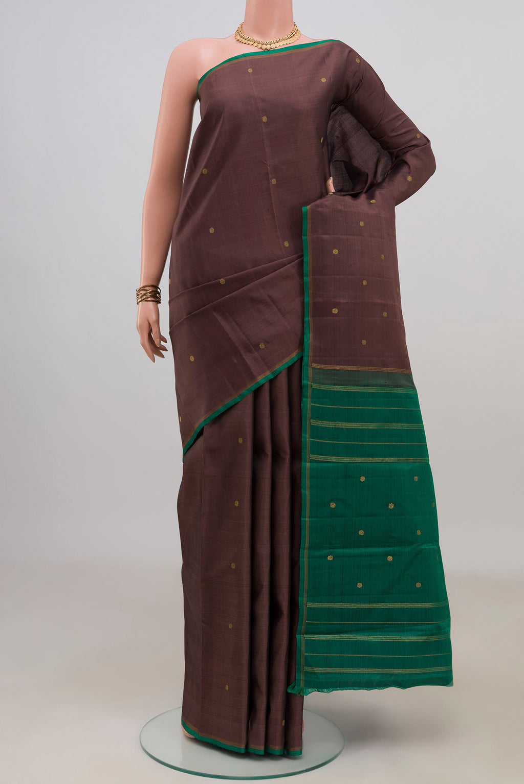 Pure Silk Pure Zari Brown Kanjivaram Saree with Zari Butta on the body and Without Border.  displayed on a mannequin