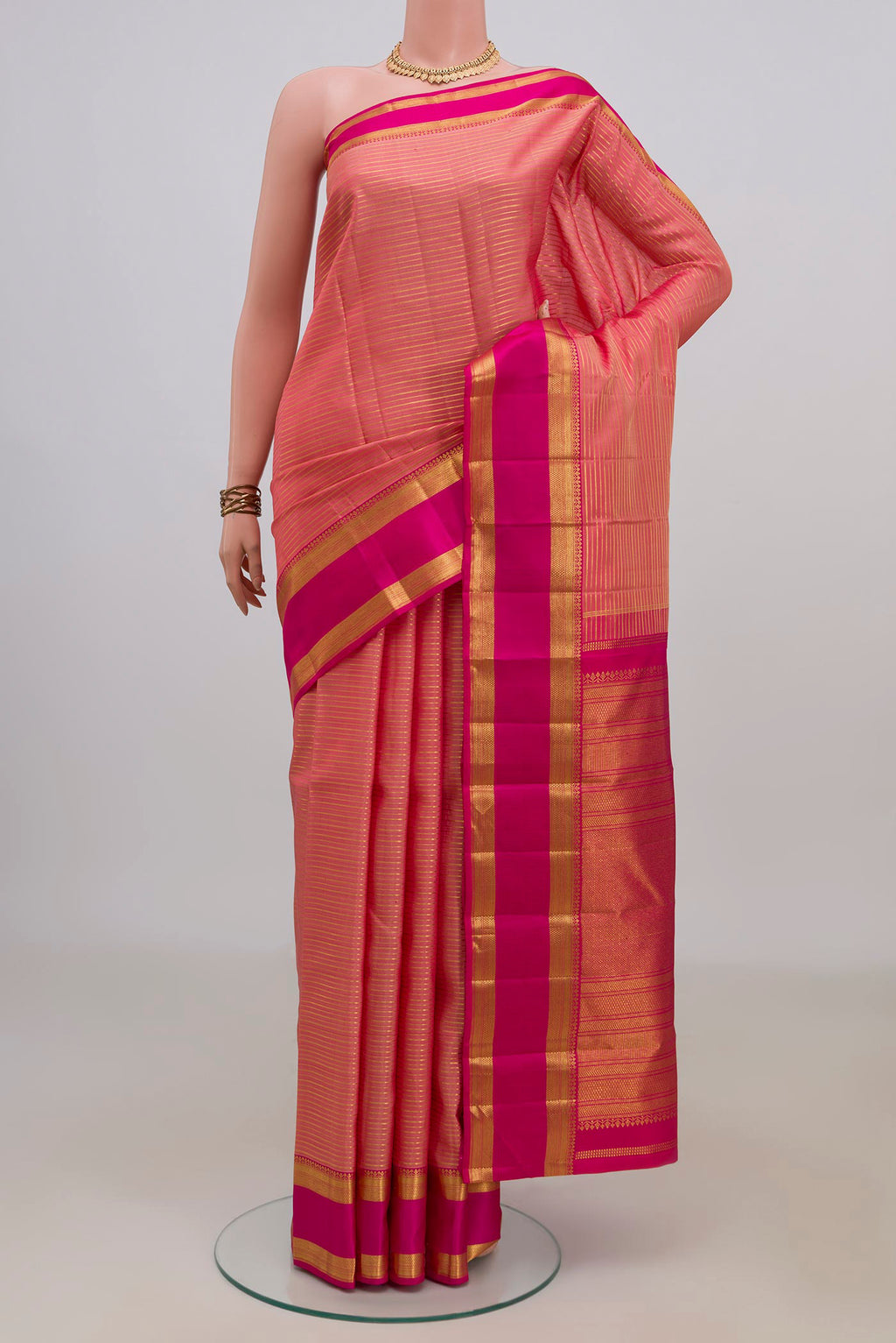 Pure Silk Peach Kanjivaram Saree with Stripes on the body and Zari Border.  displayed on a mannequin