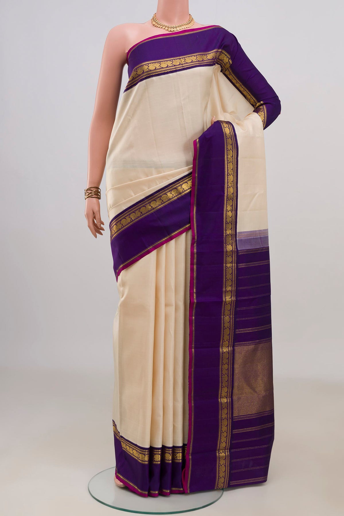 Pure Silk Cream Kanjivaram Saree with Plain Body and Zari Border.  displayed on a mannequin