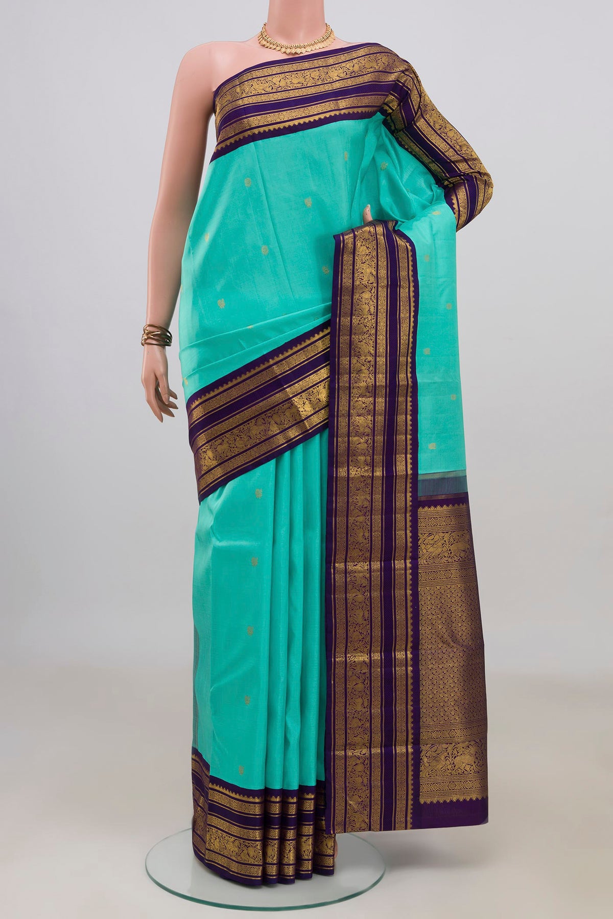 Pure Silk Pure Zari Turquoise Kanchipuram Saree with Zari Butta on the body and Zari Border.  displayed on a mannequin