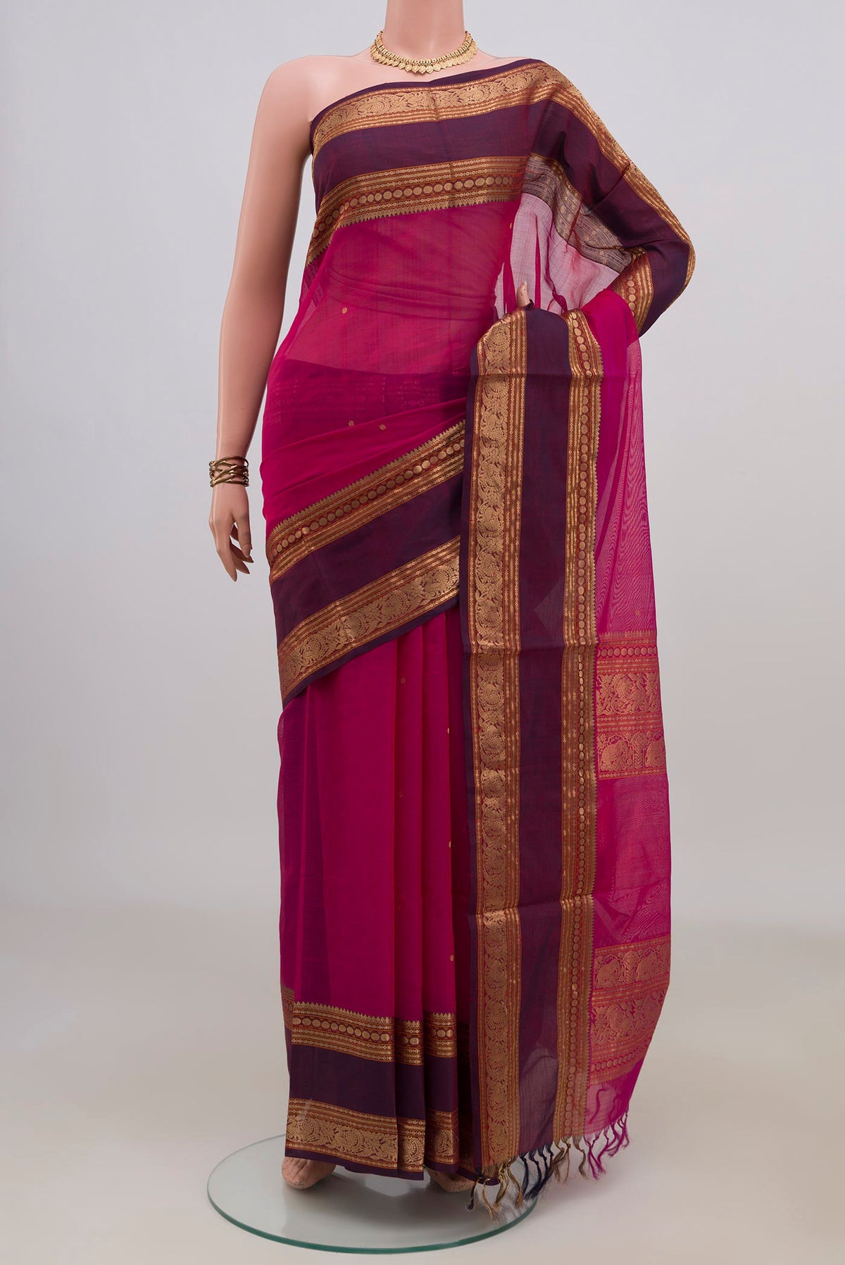 Rani Pink Silk Cotton Saree with Zari Butta on the body and Zari Border.  displayed on a mannequin