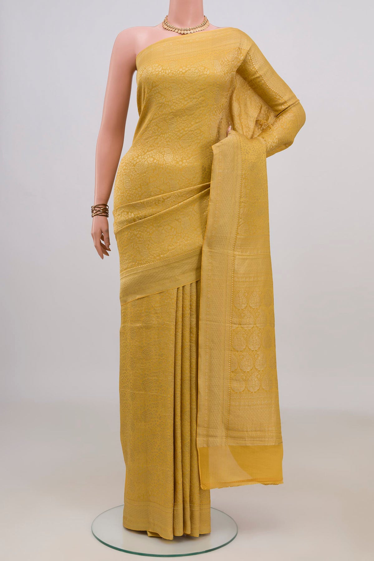 Yellow Mysore Crepe Saree with Zari Brocade on the body and Zari Border.  displayed on a mannequin