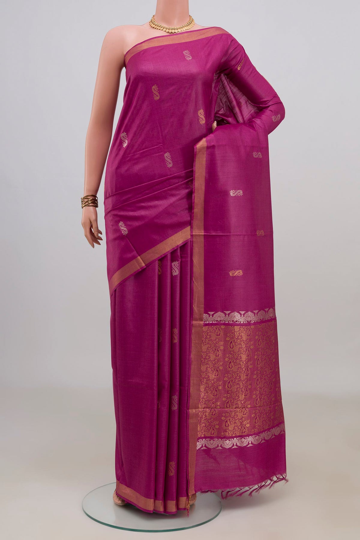 Magenta Tussar Saree with Zari Butta on the body and Zari Border.  displayed on a mannequin